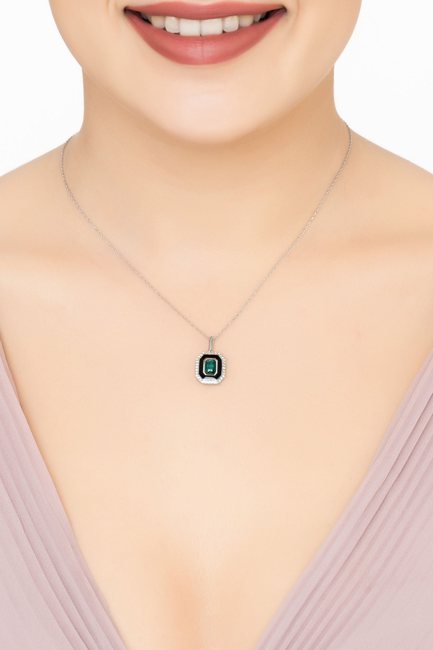 Angled view of Art Deco Emerald And Enamel Pendant Necklace Silver, showing emerald detailing, silver finish and the jewellery profile.