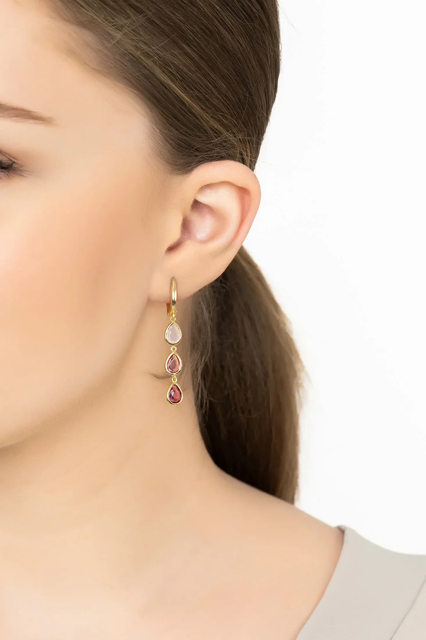 Angled view of Sardinia Triple Teardrop Earrings Gold The Pinks, showing gold finish and the jewellery profile.