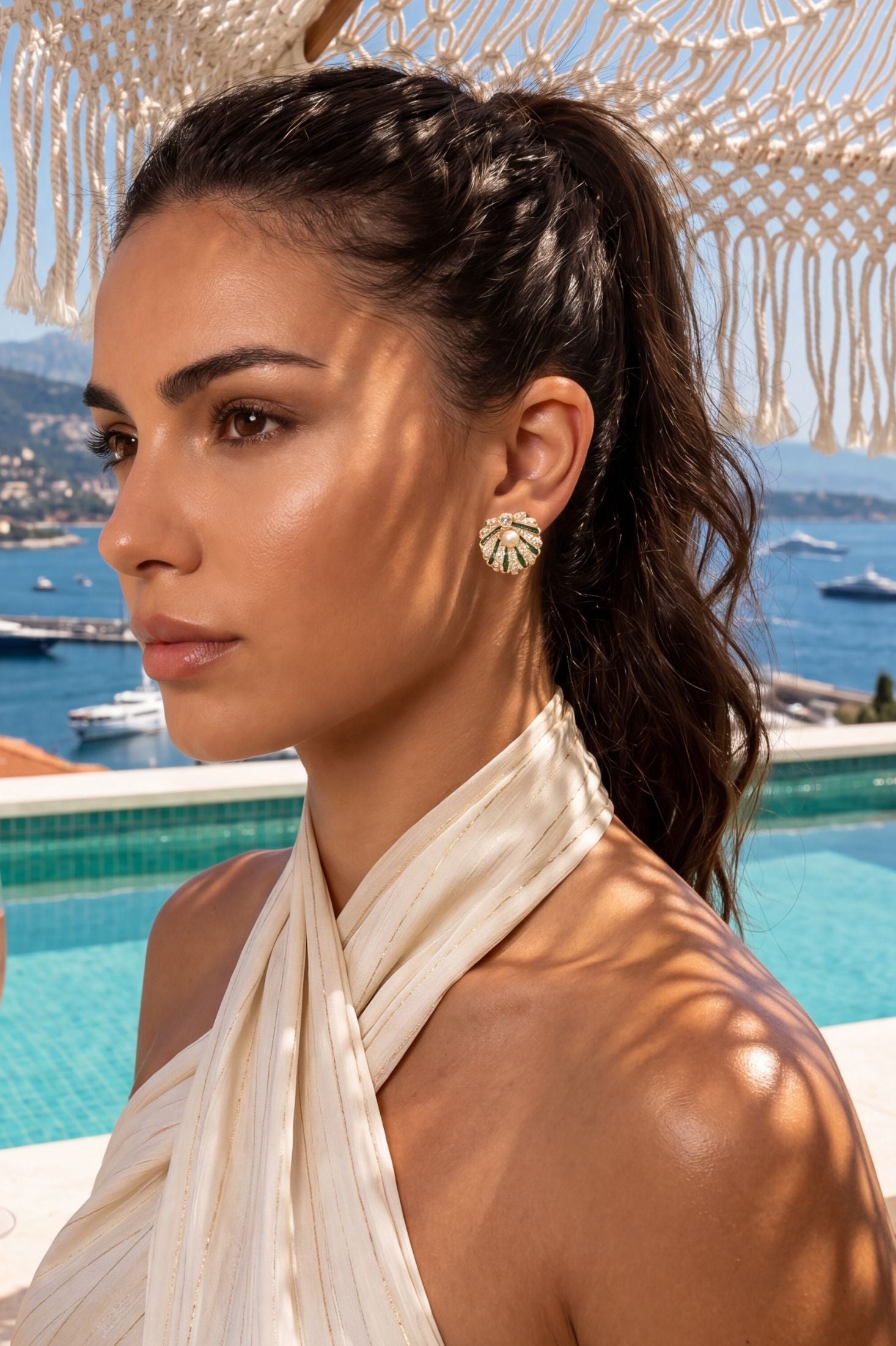 Angled view of Art Deco Scallop Shell Earrings Emerald Green With Pearl Gold, showing shell design, pearl and emerald detailing, gold finish and the jewellery profile.