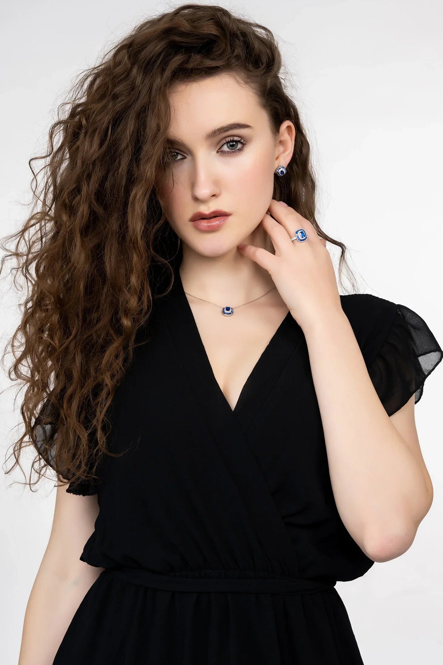Woman wearing a black dress with jewelry on a white background