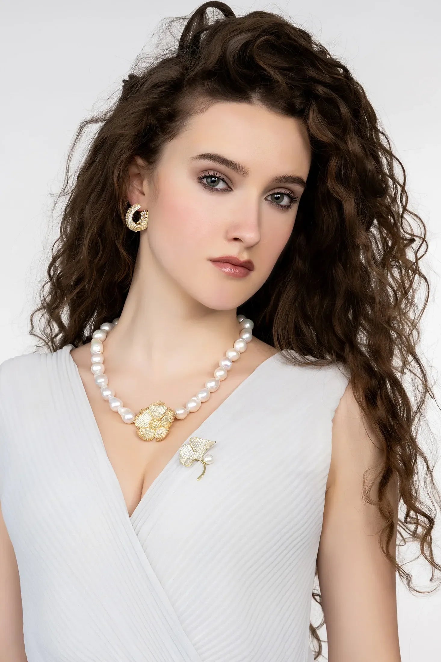 Angled view of Ginkgo Leaf And Pearl Brooch Gold, showing leaf design, pearl detailing, gold finish and the jewellery profile.