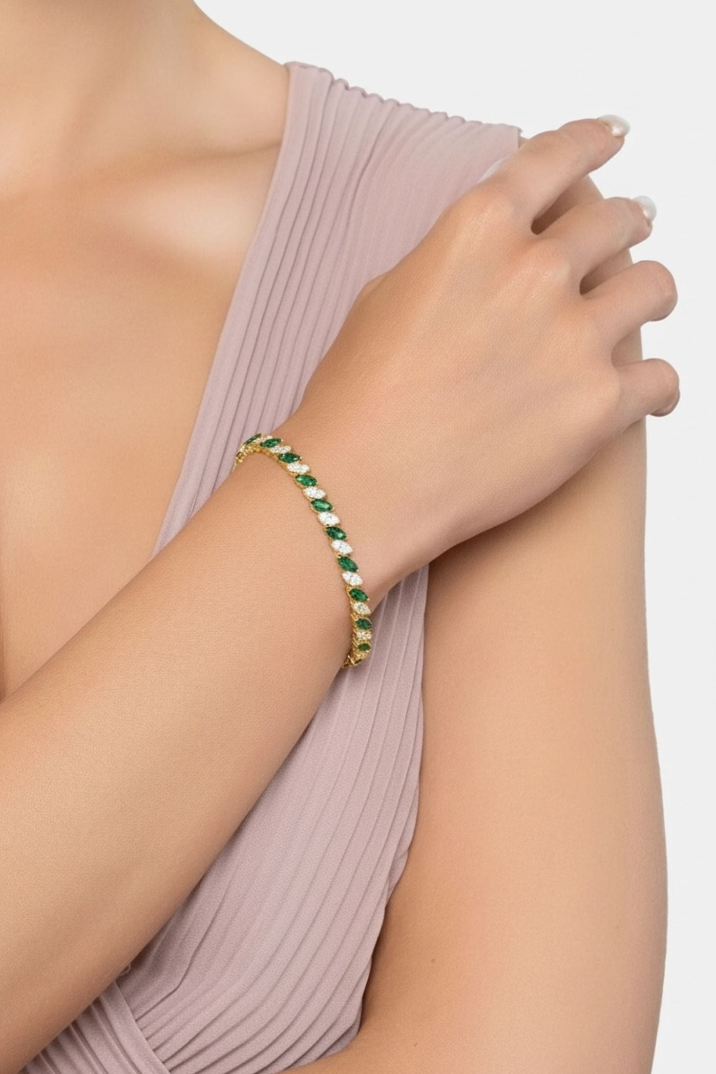 Gold and green bracelet worn by a model.