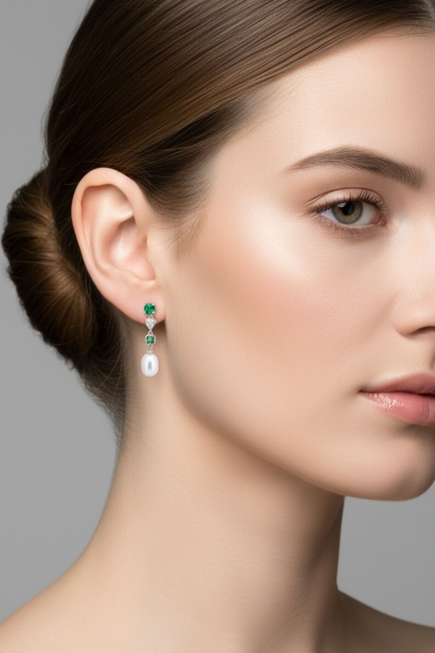 Angled view of Pearl Whisper Drop Earrings Colombian Emerald Silver, showing pearl and emerald detailing, silver finish and the jewellery profile.