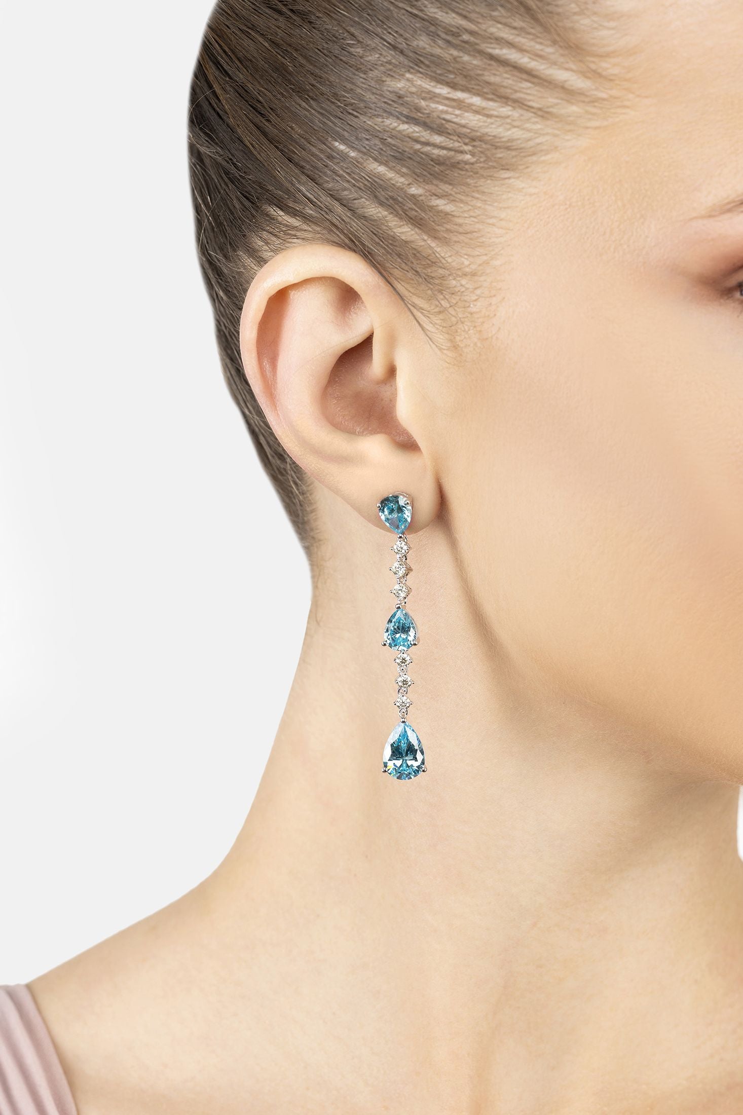 Angled view of Elizabeth Drop Earrings Blue Topaz Silver, showing blue topaz detailing, silver finish and the jewellery profile.