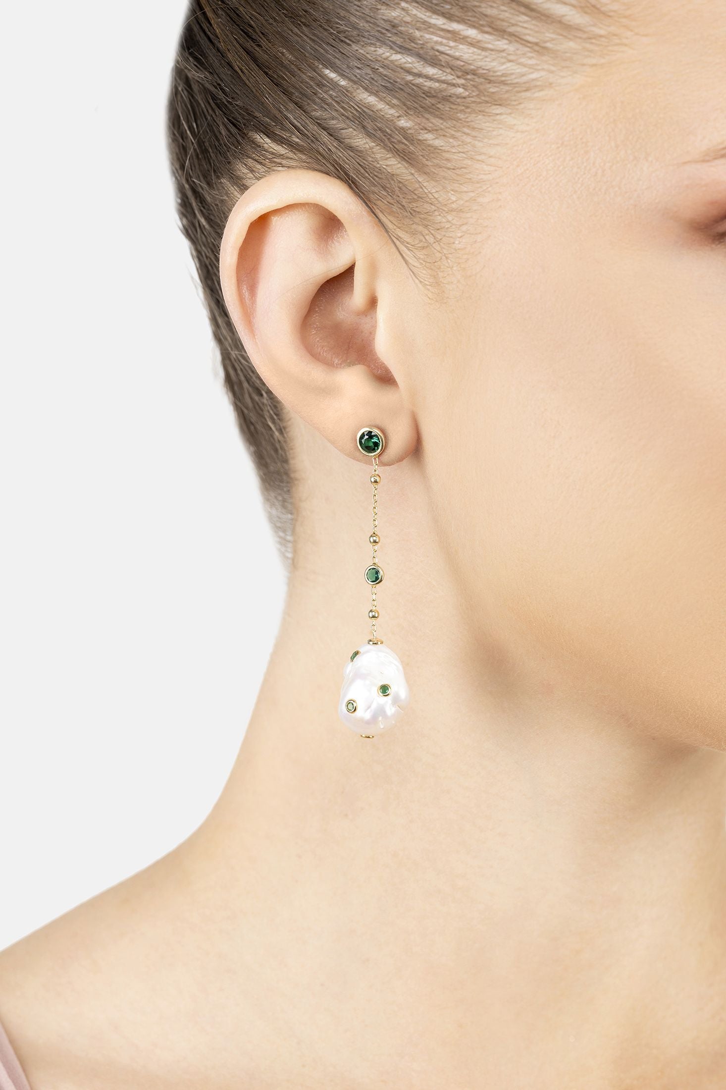 Angled view of Polka Dot Baroque Pearl Chain Drop Earrings Gold Emerald, showing baroque pearl and pearl detailing, gold finish and the jewellery profile.
