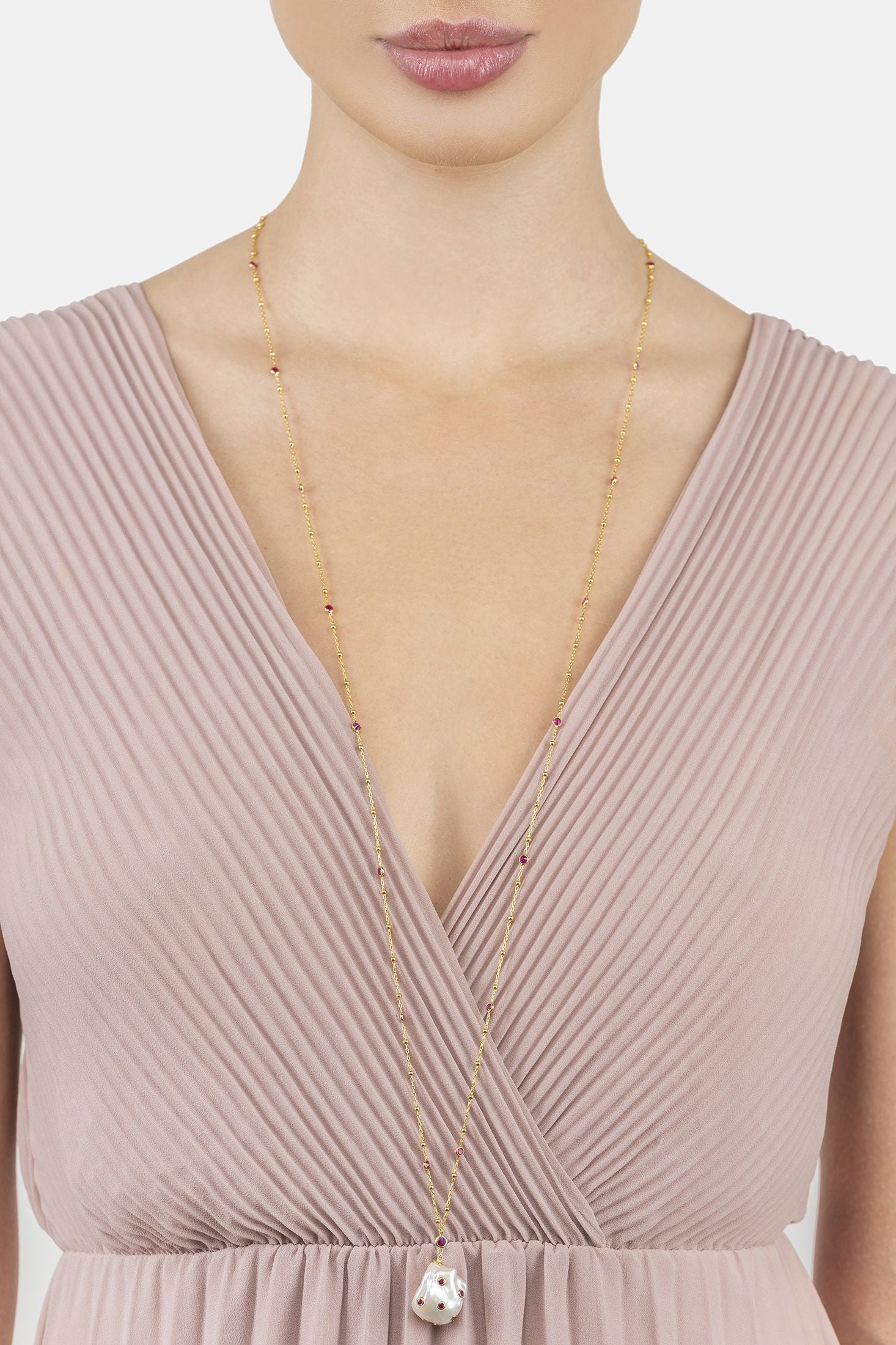 Angled view of Polka Dot Baroque Pearl Long Necklace Gold Ruby, showing baroque pearl and pearl detailing, gold finish and the jewellery profile.