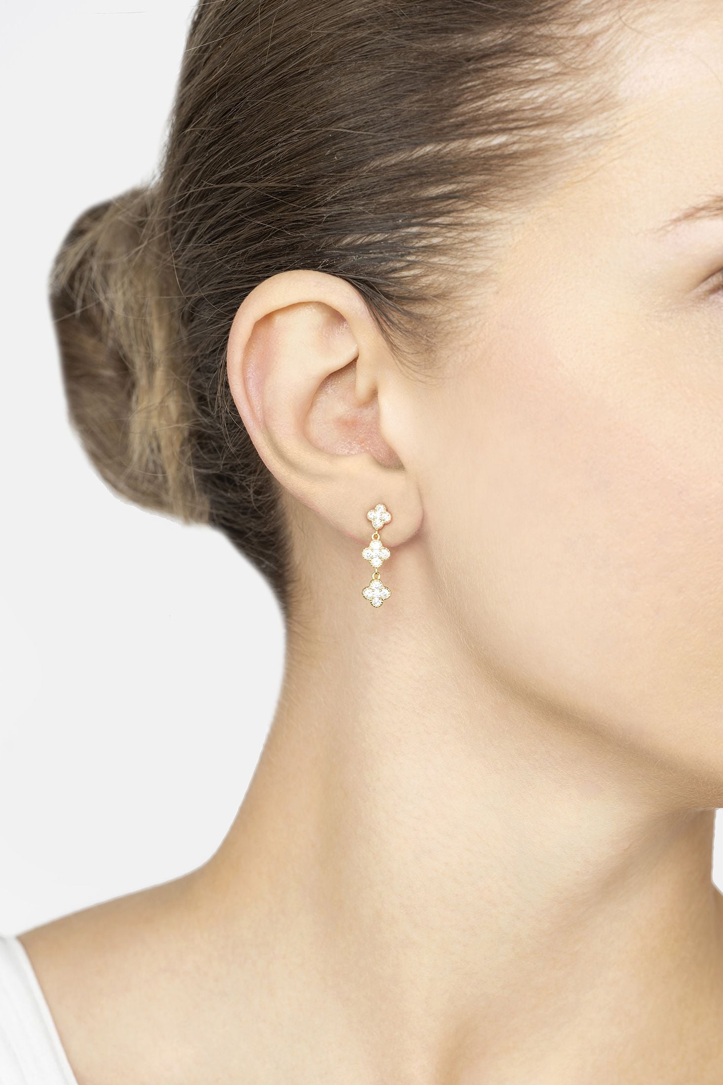 Close-up of a woman wearing a delicate earring with a white background