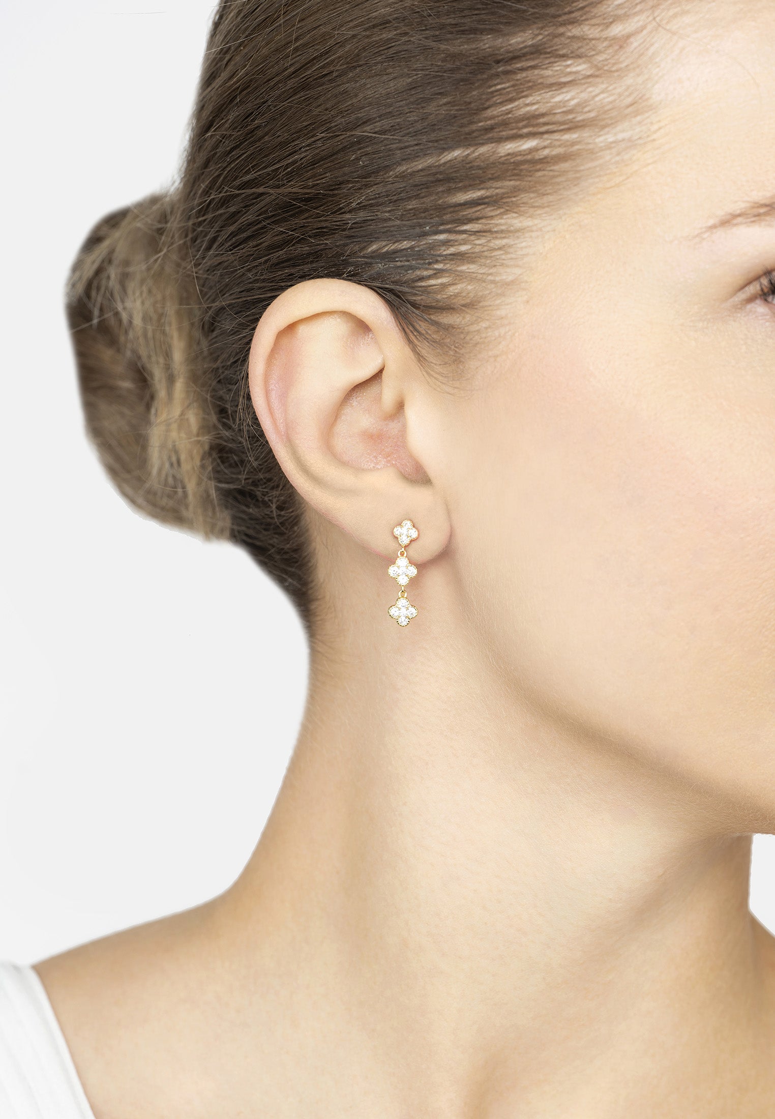 Close-up of a woman wearing a delicate earring with a white background