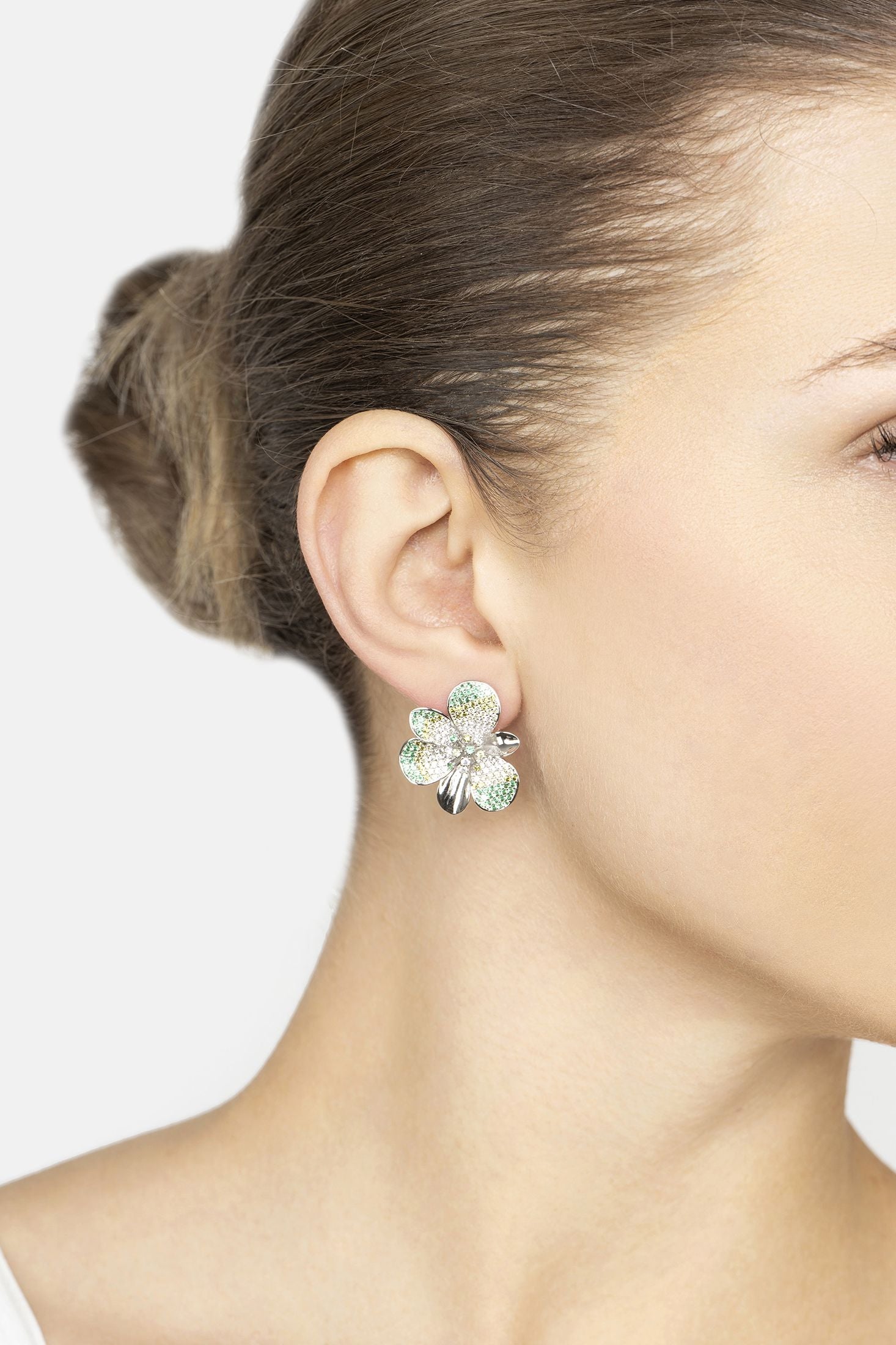 Close-up of a woman wearing a floral earring with a white background