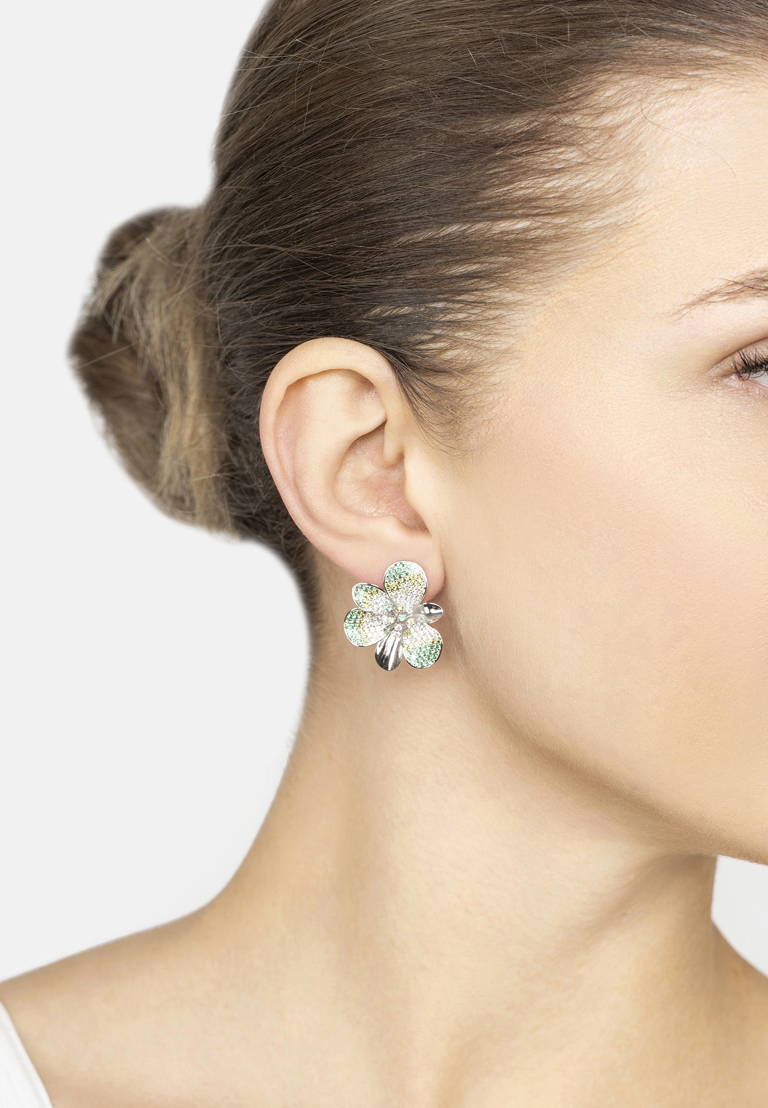 Close-up of a woman wearing a floral earring with a white background