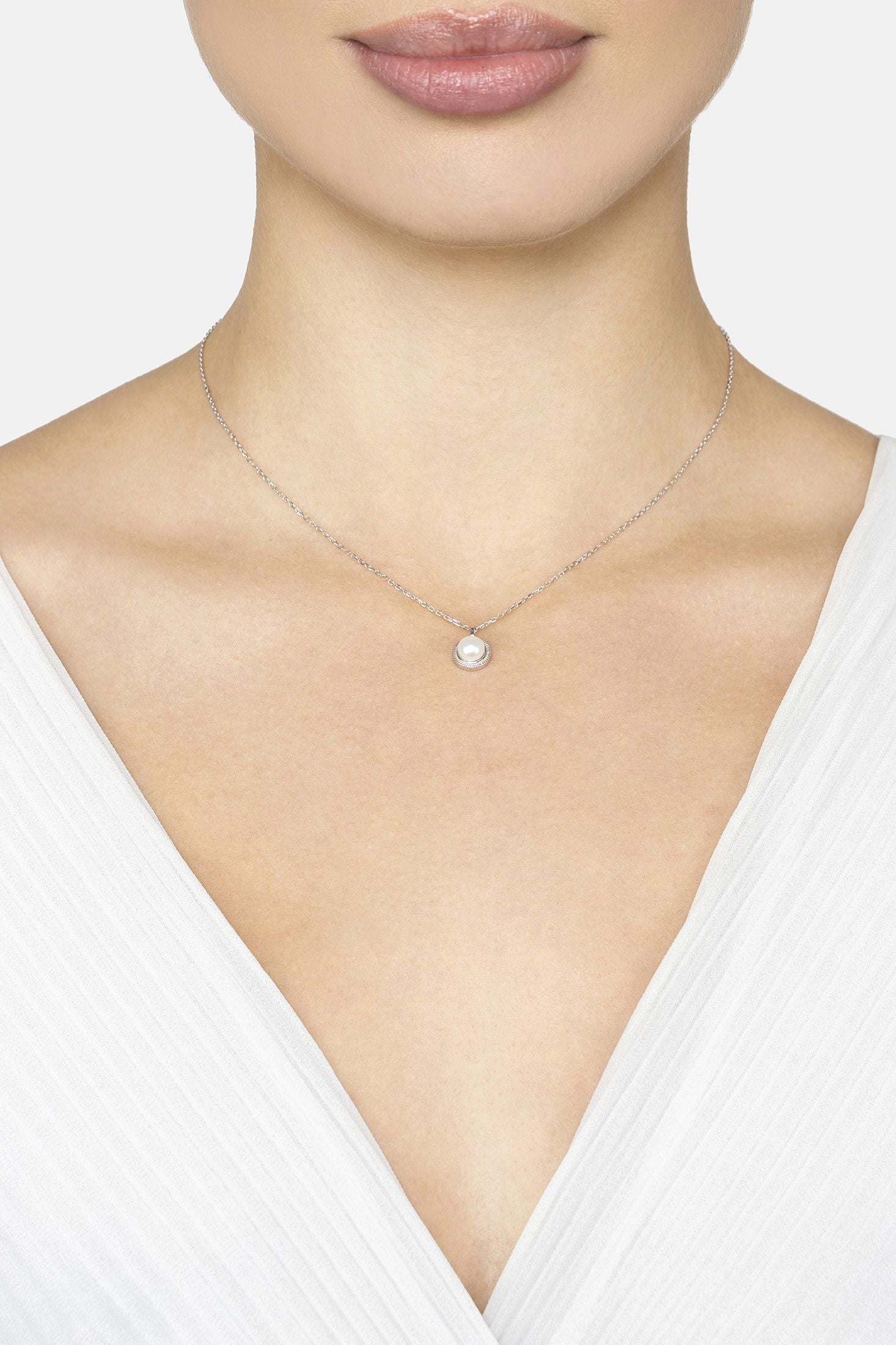 Necklace with a pendant on a model wearing a white top