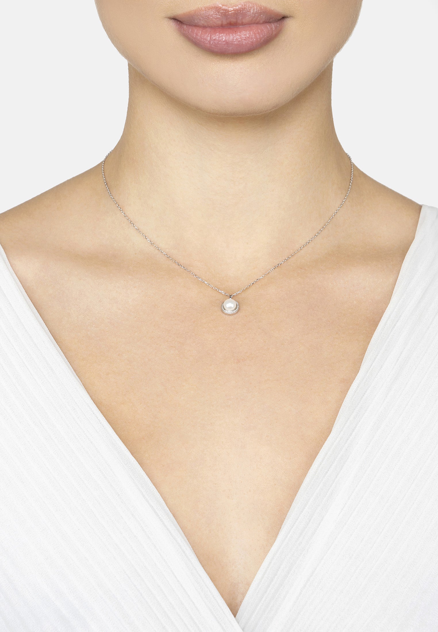 Necklace with a pendant on a model wearing a white top