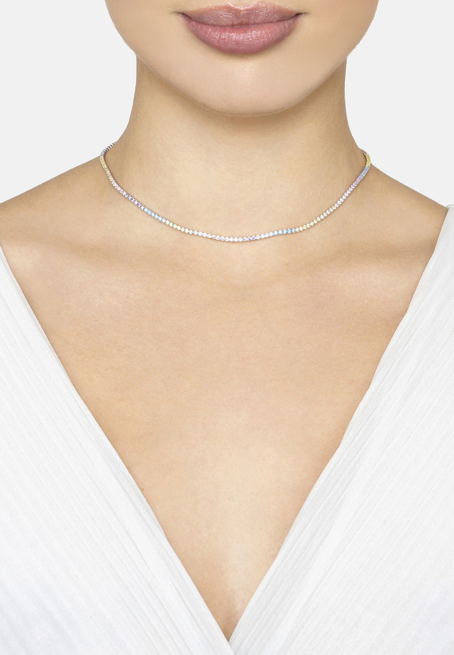 Silver necklace worn by a person in a white top
