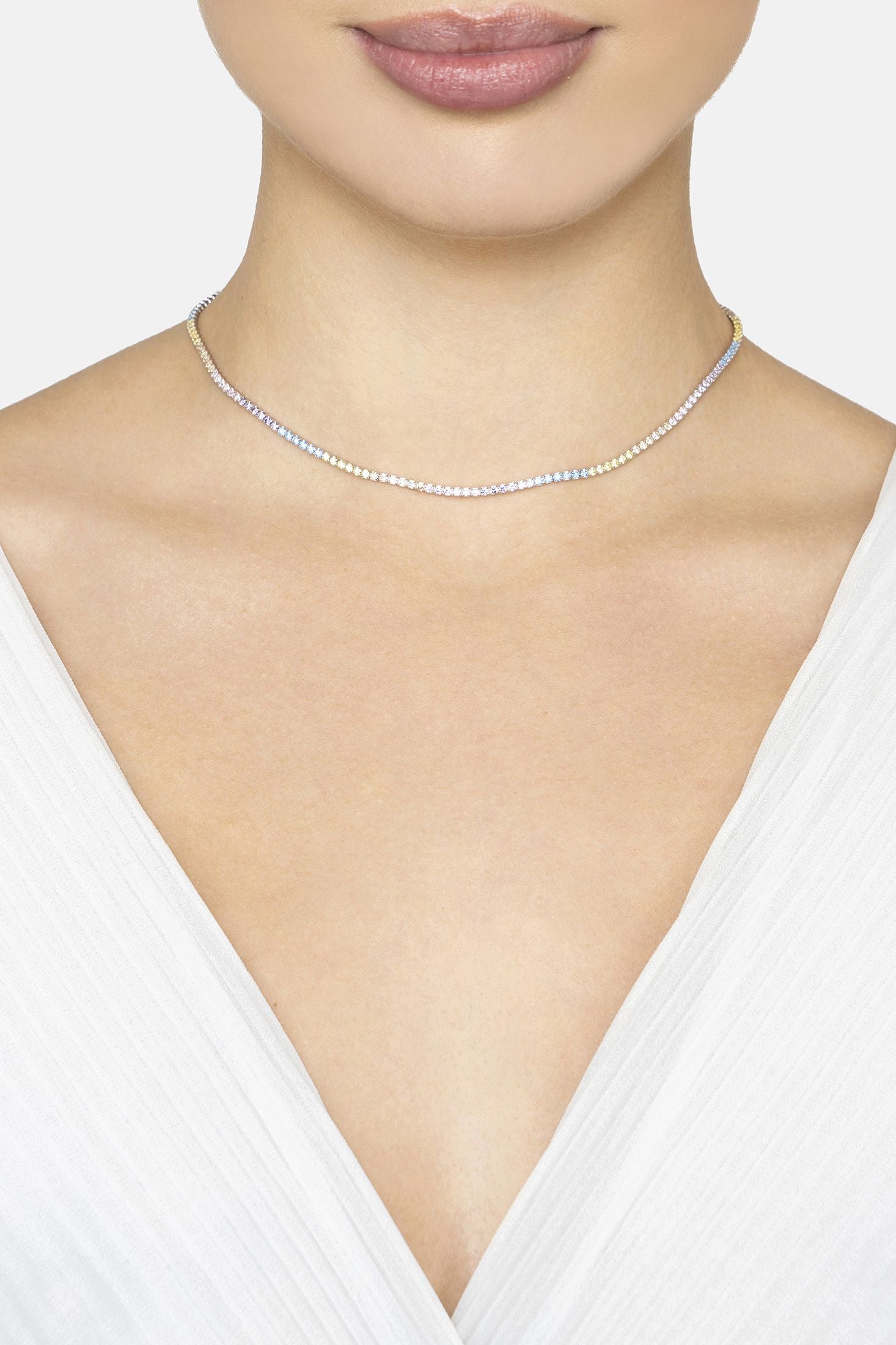 Silver necklace worn by a person in a white top