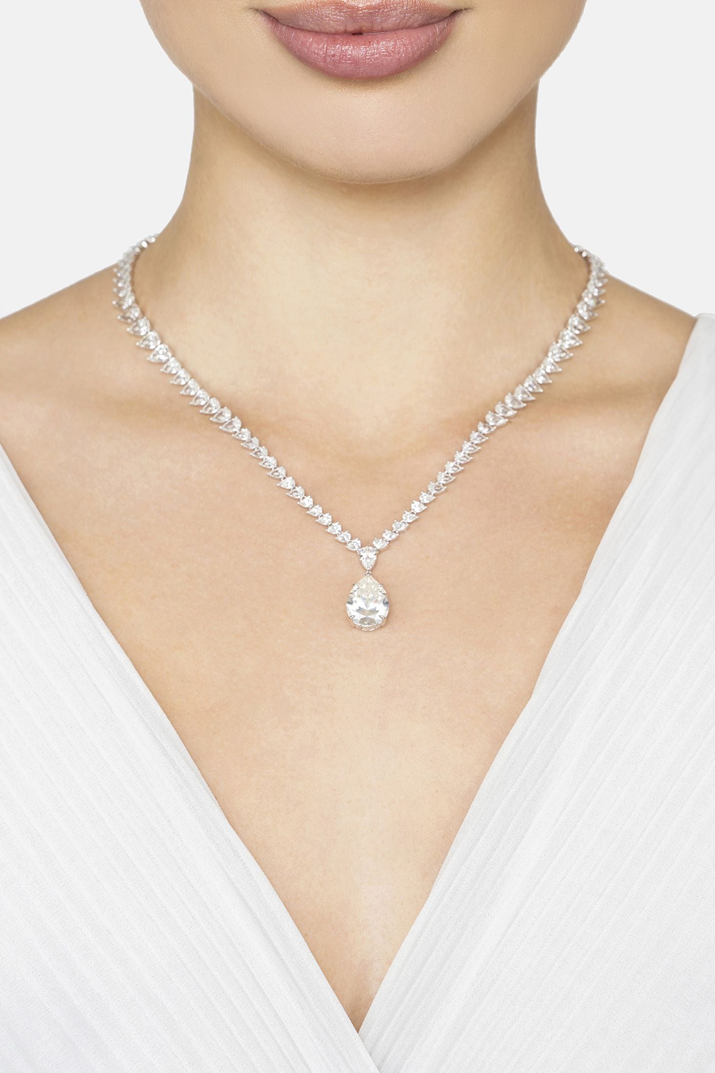 Necklace with a pendant worn by a person in a white top on a light background