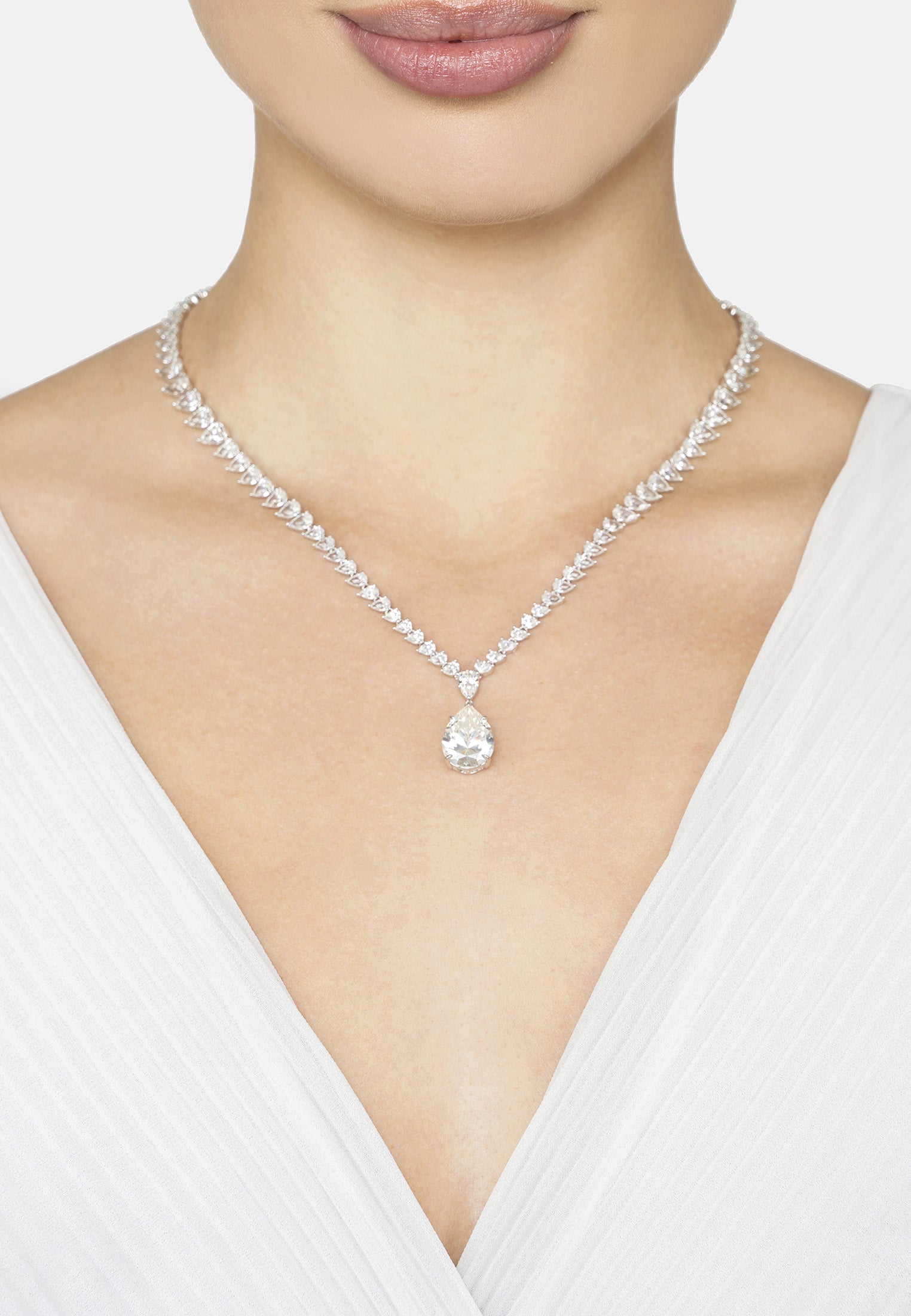 Necklace with a pendant worn by a person in a white top on a light background