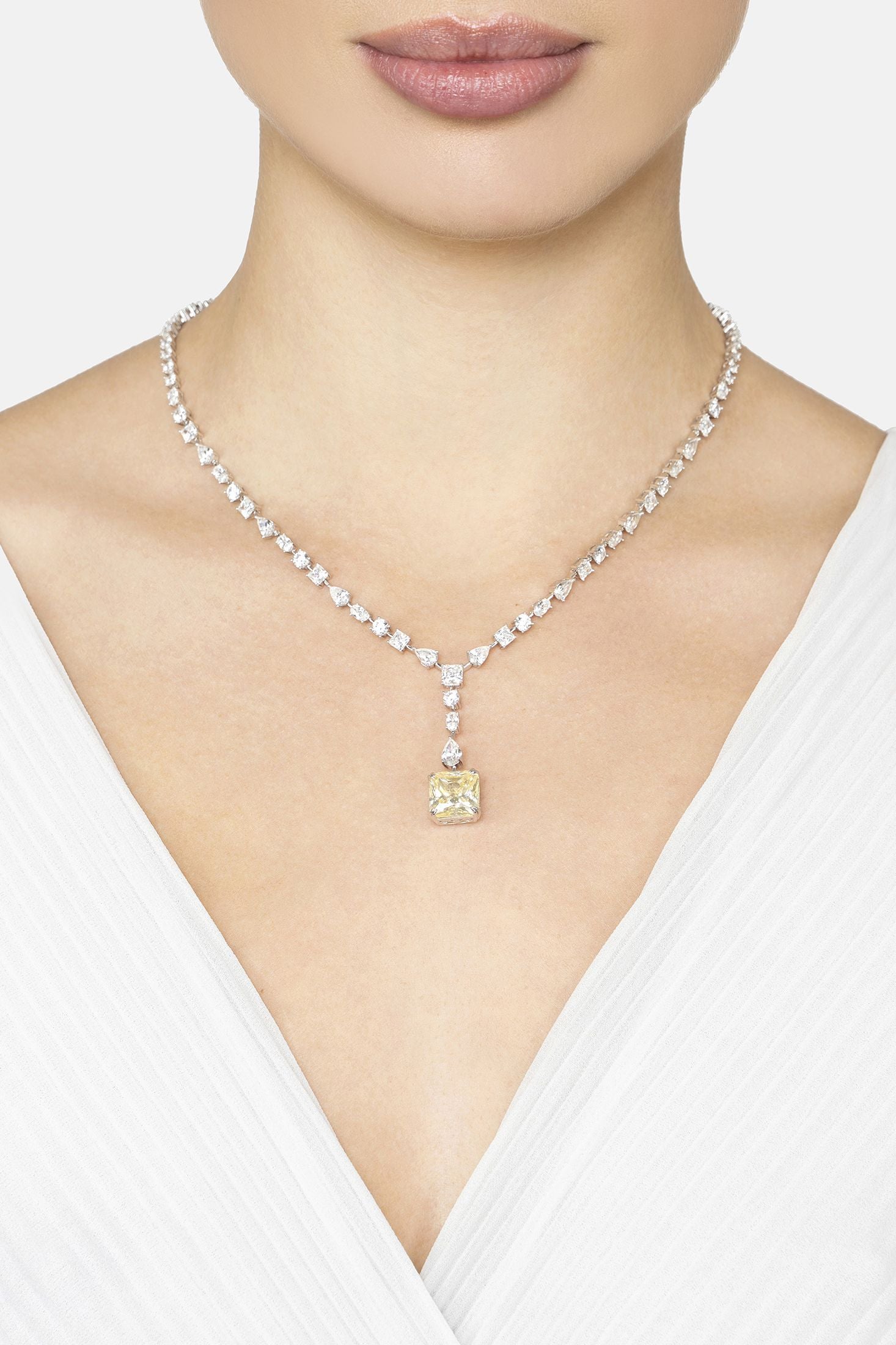 Necklace with a yellow pendant worn by a person against a white background