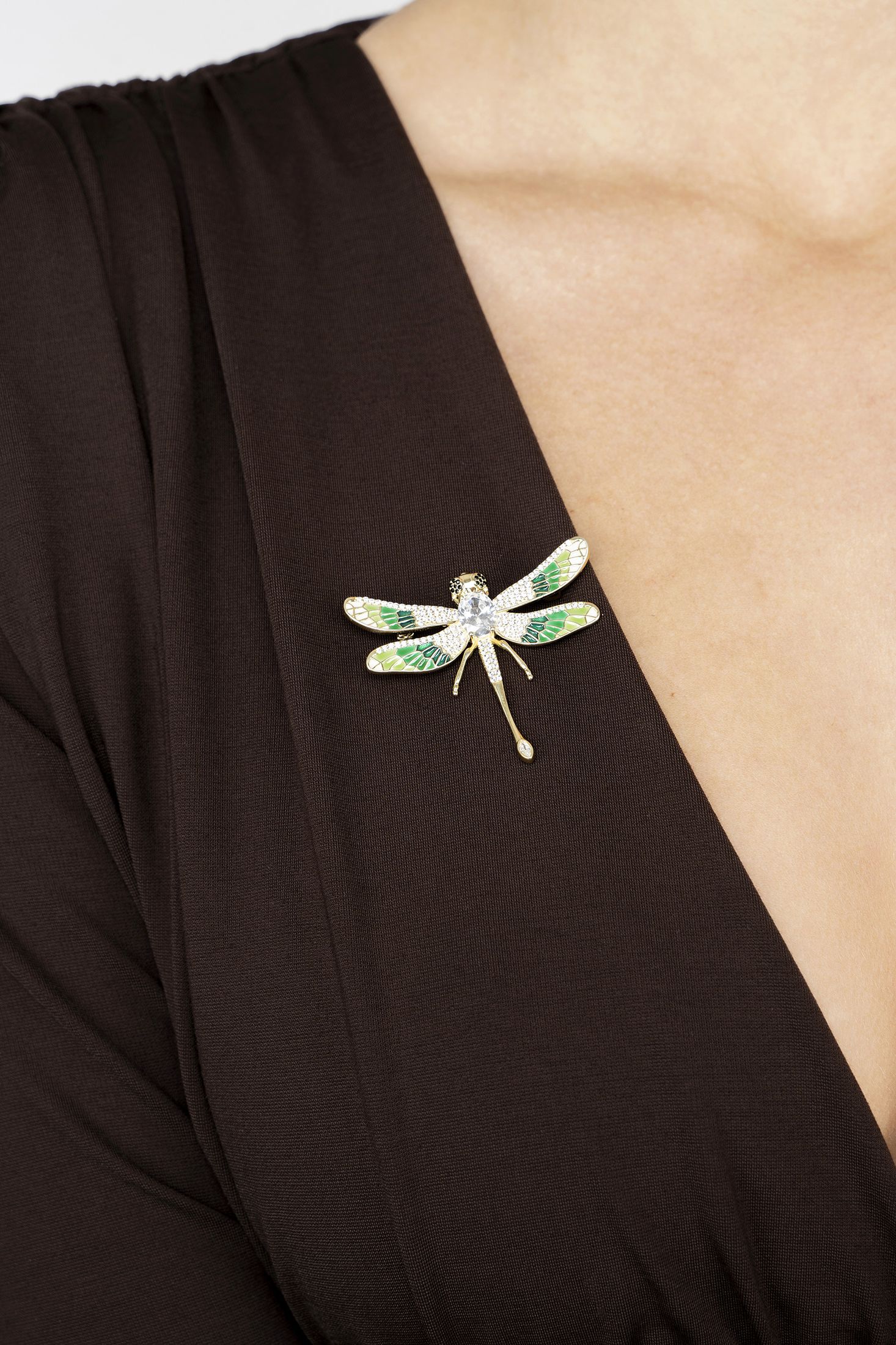Dragonfly brooch on a black garment with a beige background