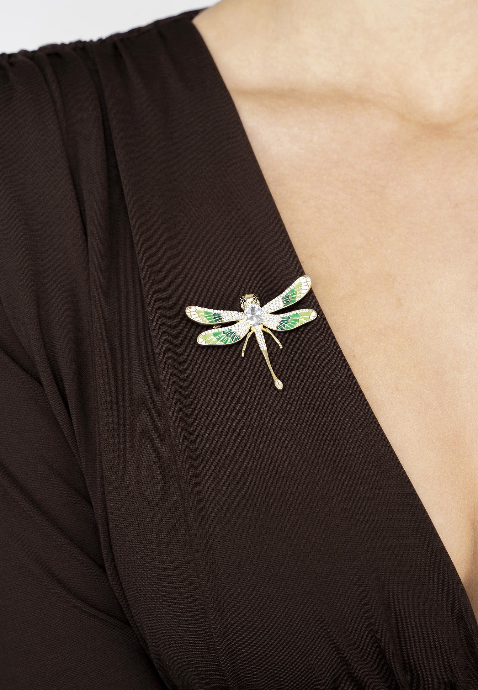 Dragonfly brooch on a black garment with a beige background