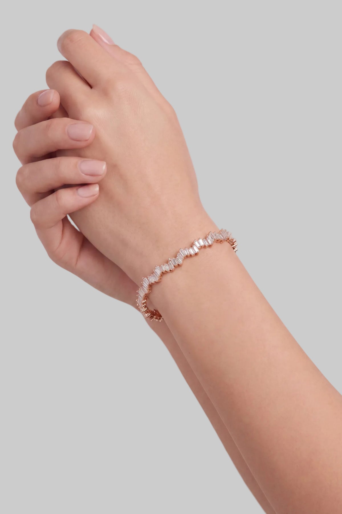 Elegant rose gold baguette diamond bracelet worn on a woman's wrist.