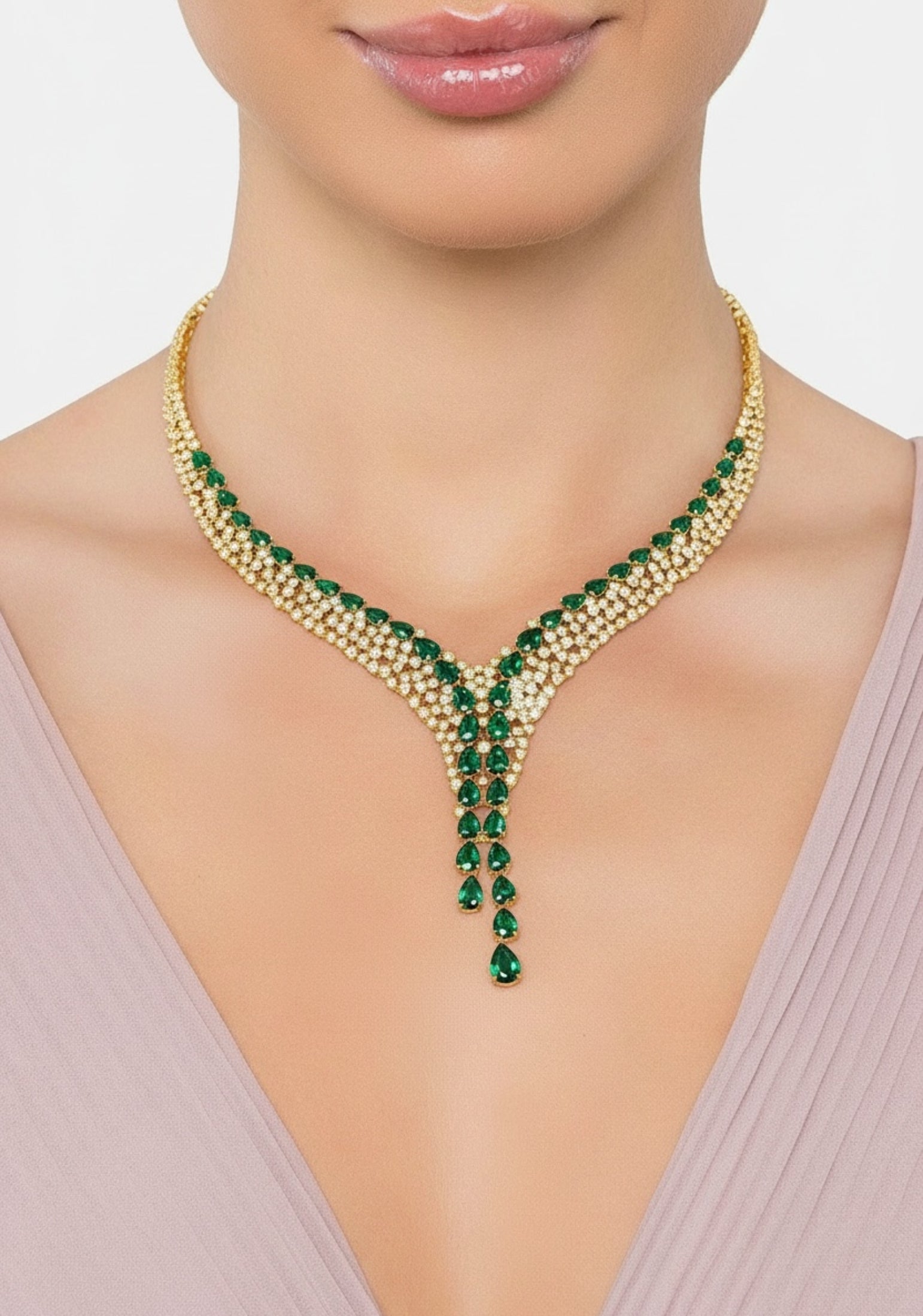 Gold statement necklace with green gemstones worn by a model.