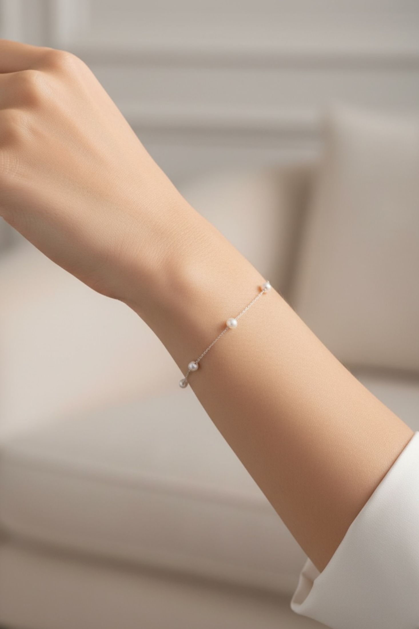 Pearl bracelet on a person's wrist with a blurred background