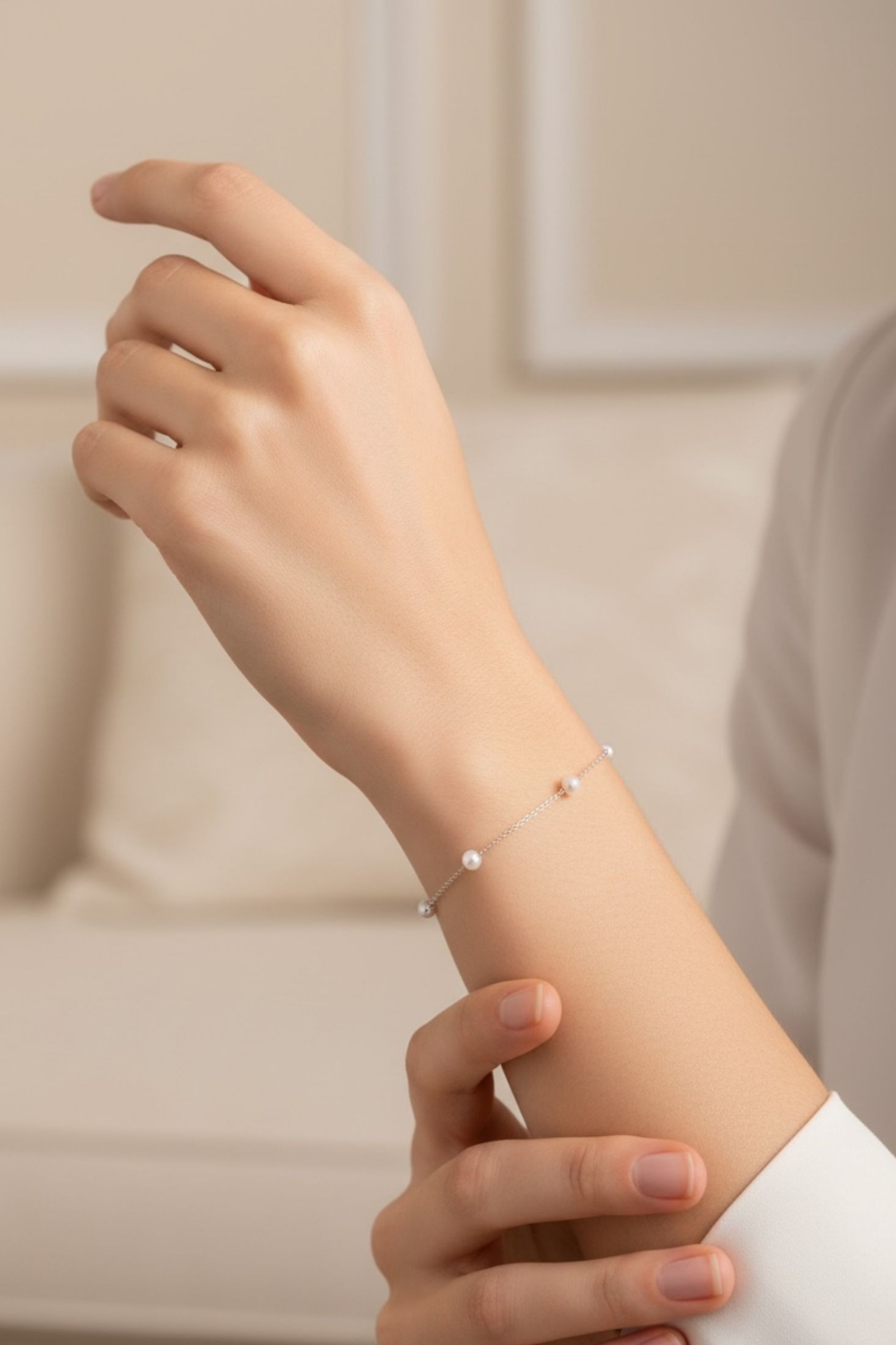 Hand wearing a delicate bracelet with a blurred background