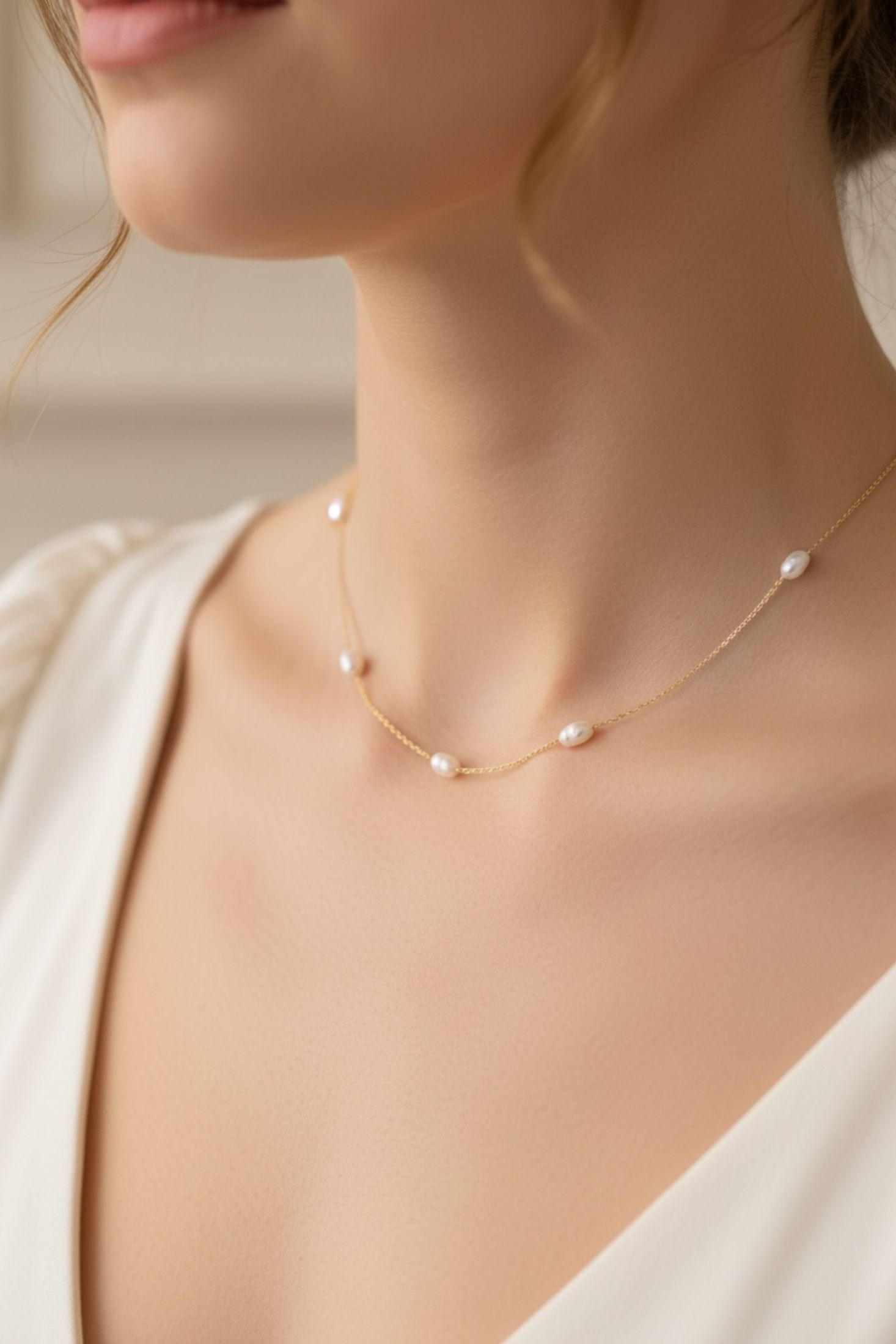 Pearl necklace worn by a model against a neutral background
