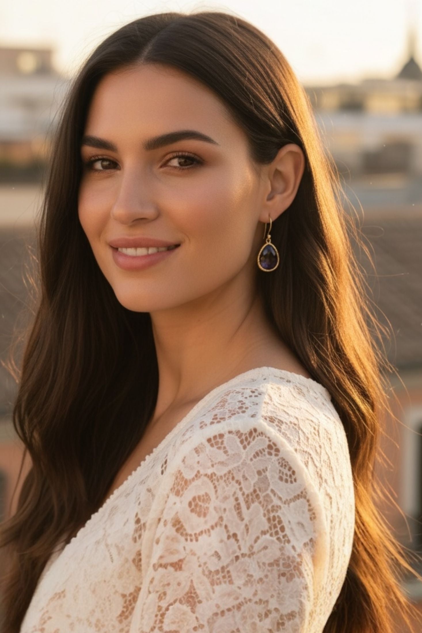 Woman wearing a white top and purple drop earrings