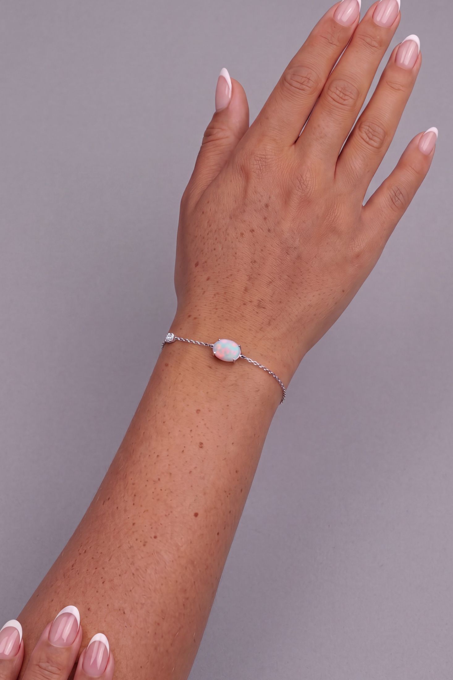 Angled view of Oval White Opal Bracelet Silver, showing silver finish and the jewellery profile.