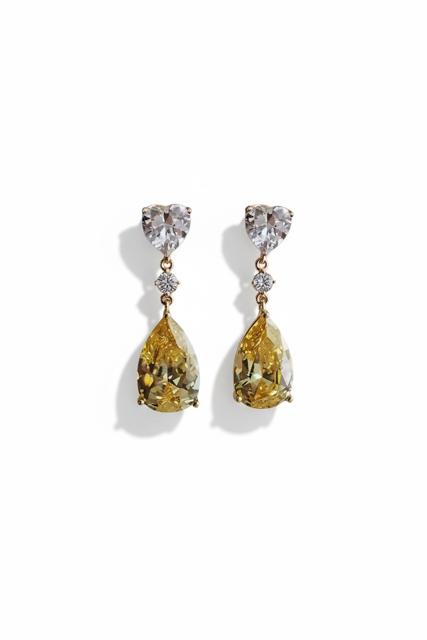 Pair of gold teardrop earrings with clear gemstones on a white background