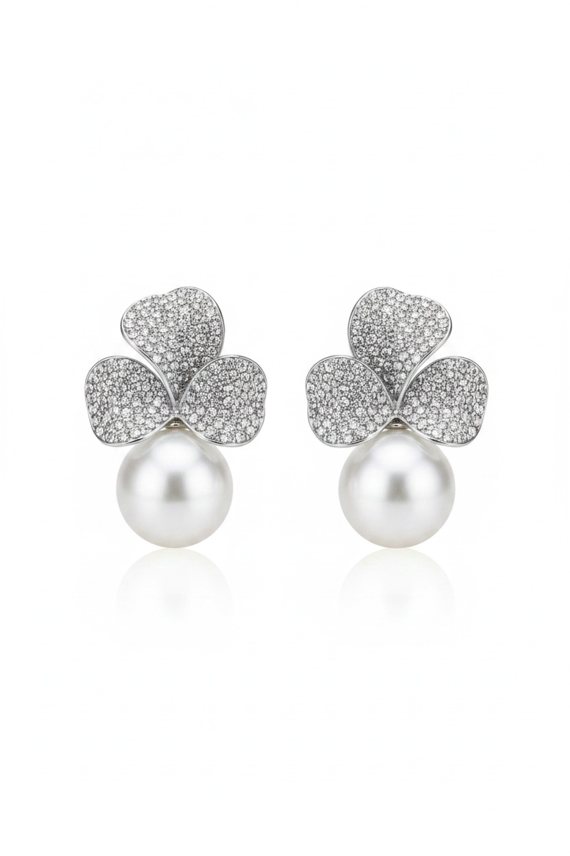 Pair of earrings with clover-shaped silver tops and pearls on a white background