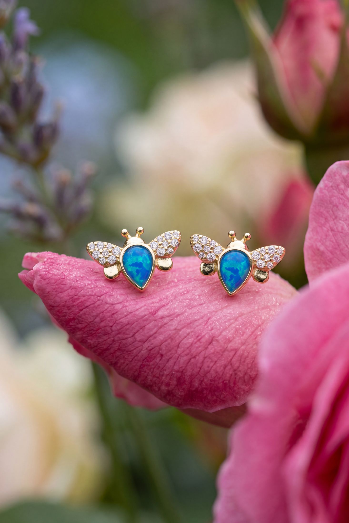 Busy Bee Blue Opal Stud Earrings Gold worn by a model, showing how they sit on the ear and their scale.