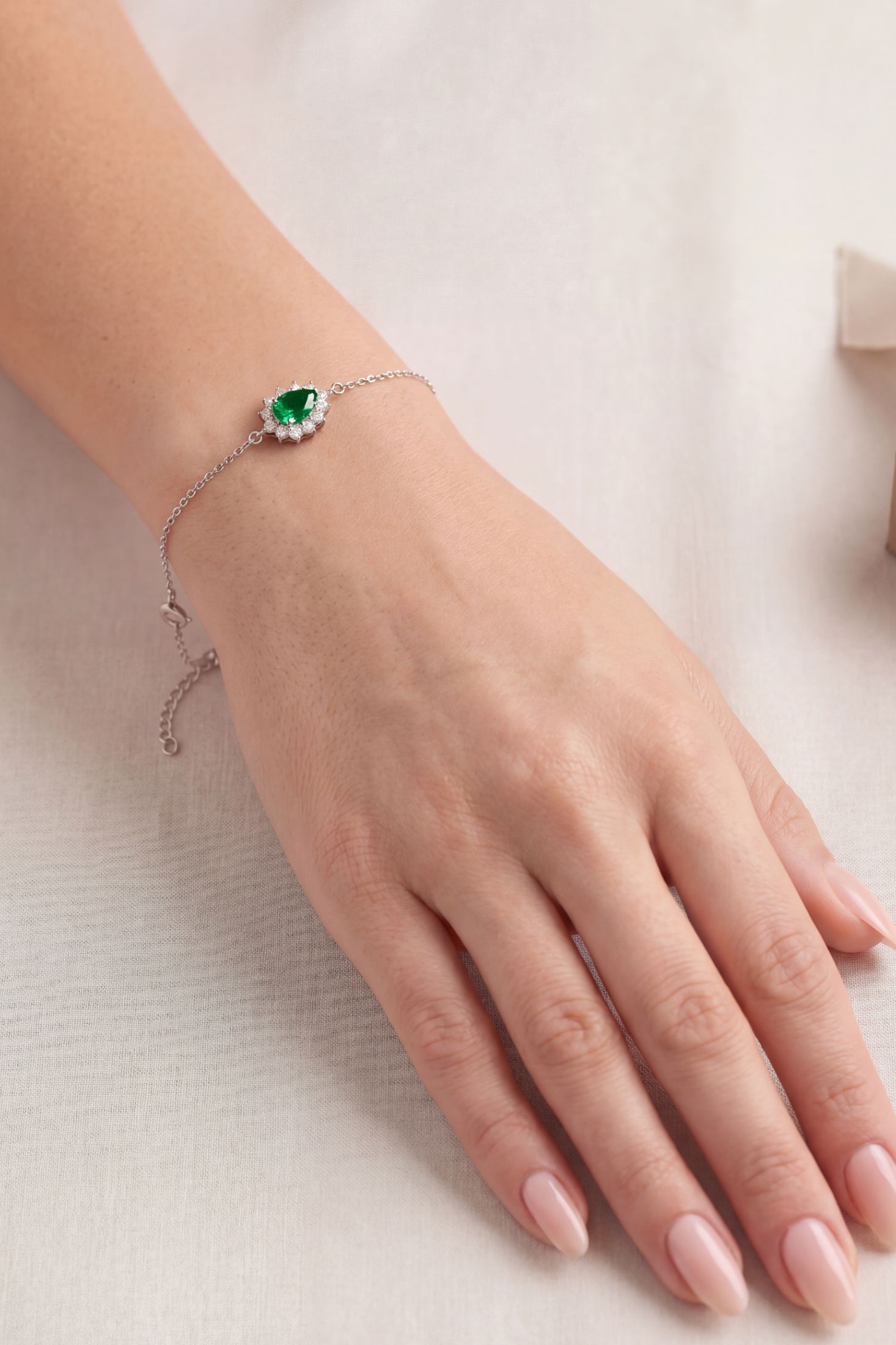 Angled view of Phillippa Bracelet Emerald Silver, showing emerald detailing, silver finish and the jewellery profile.