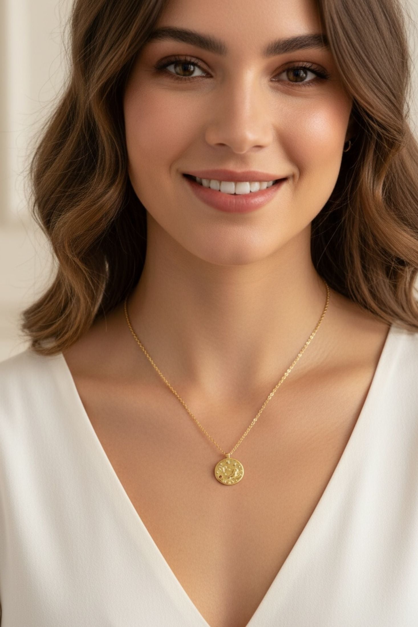 Gold pendant necklace worn by a model.