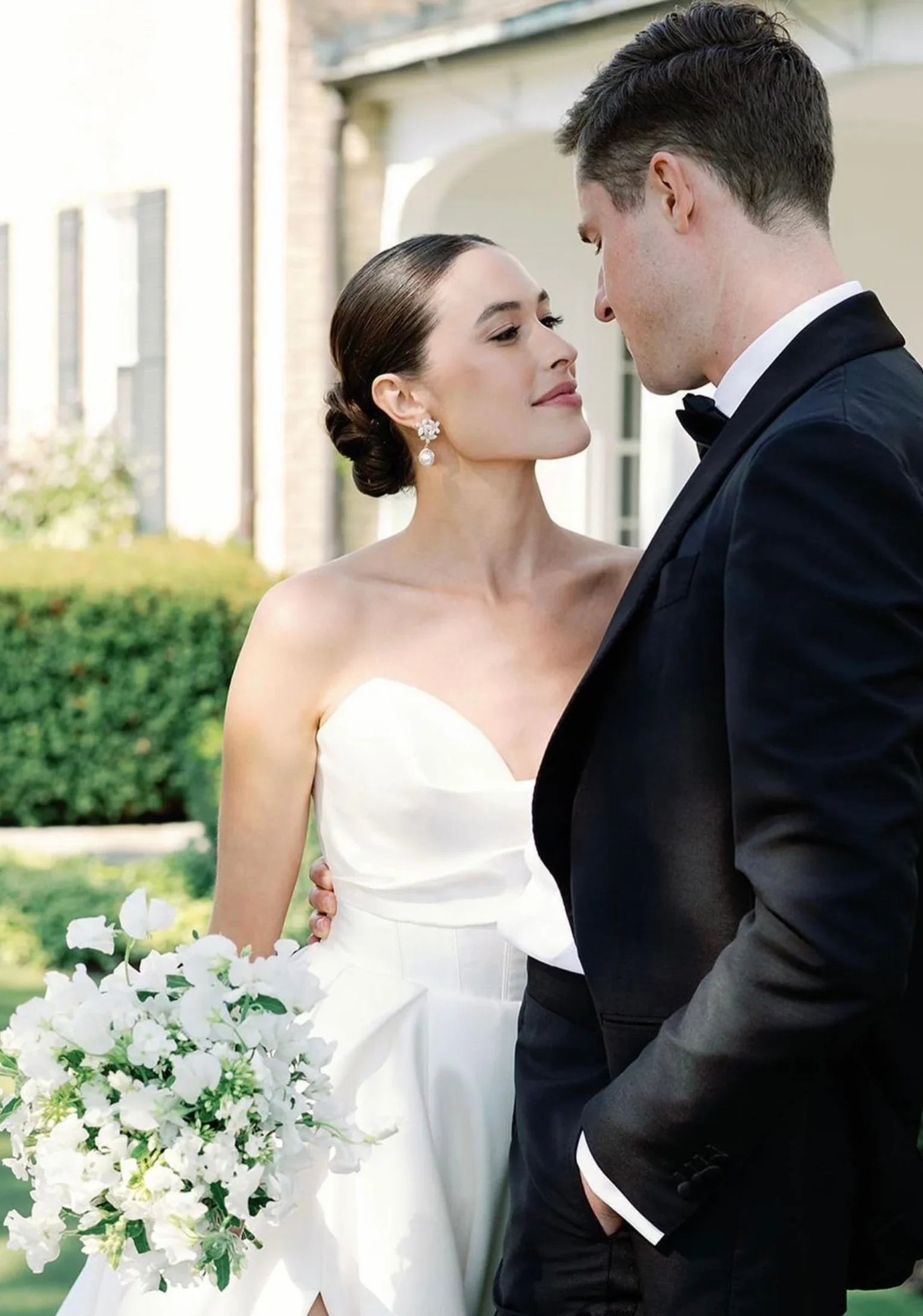 The earring worn by a bride posing with the groom.