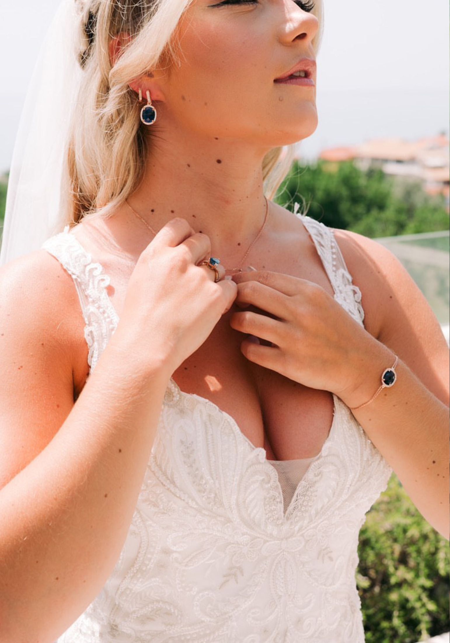 Diamond halo sapphire jewelry set worn by a bride.