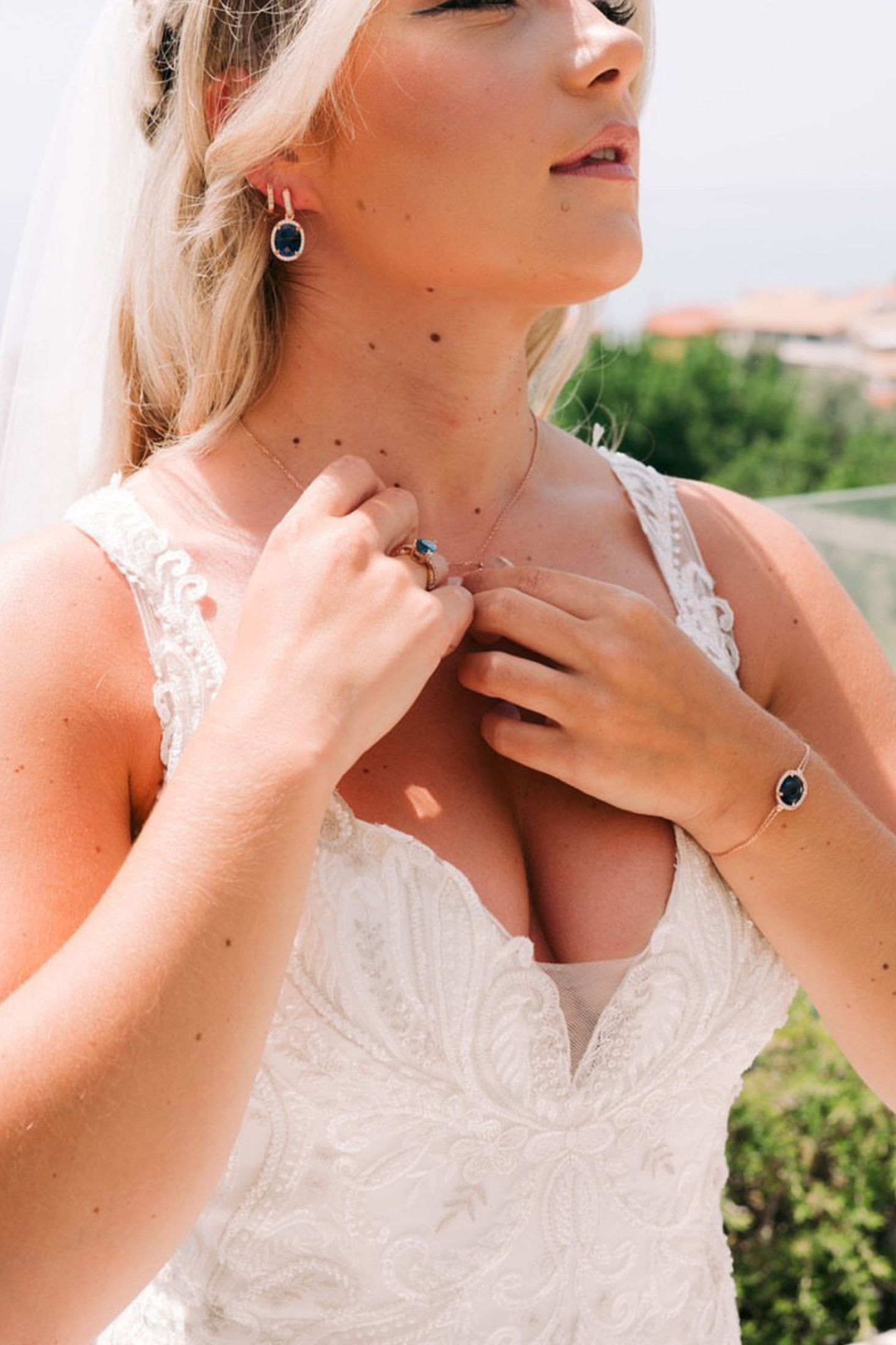 Diamond halo sapphire jewelry set worn by a bride.
