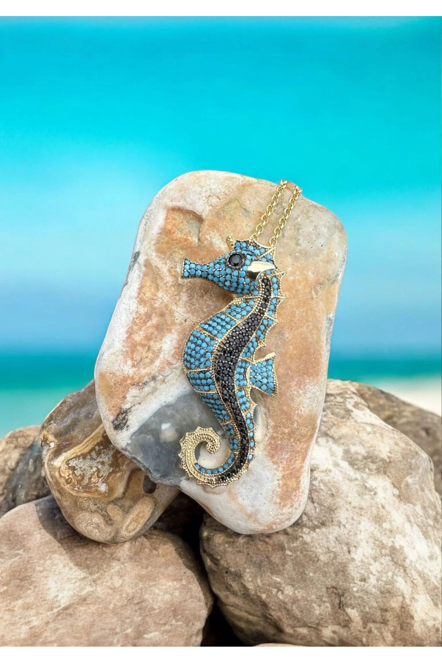 The necklace against rocks on a beach.