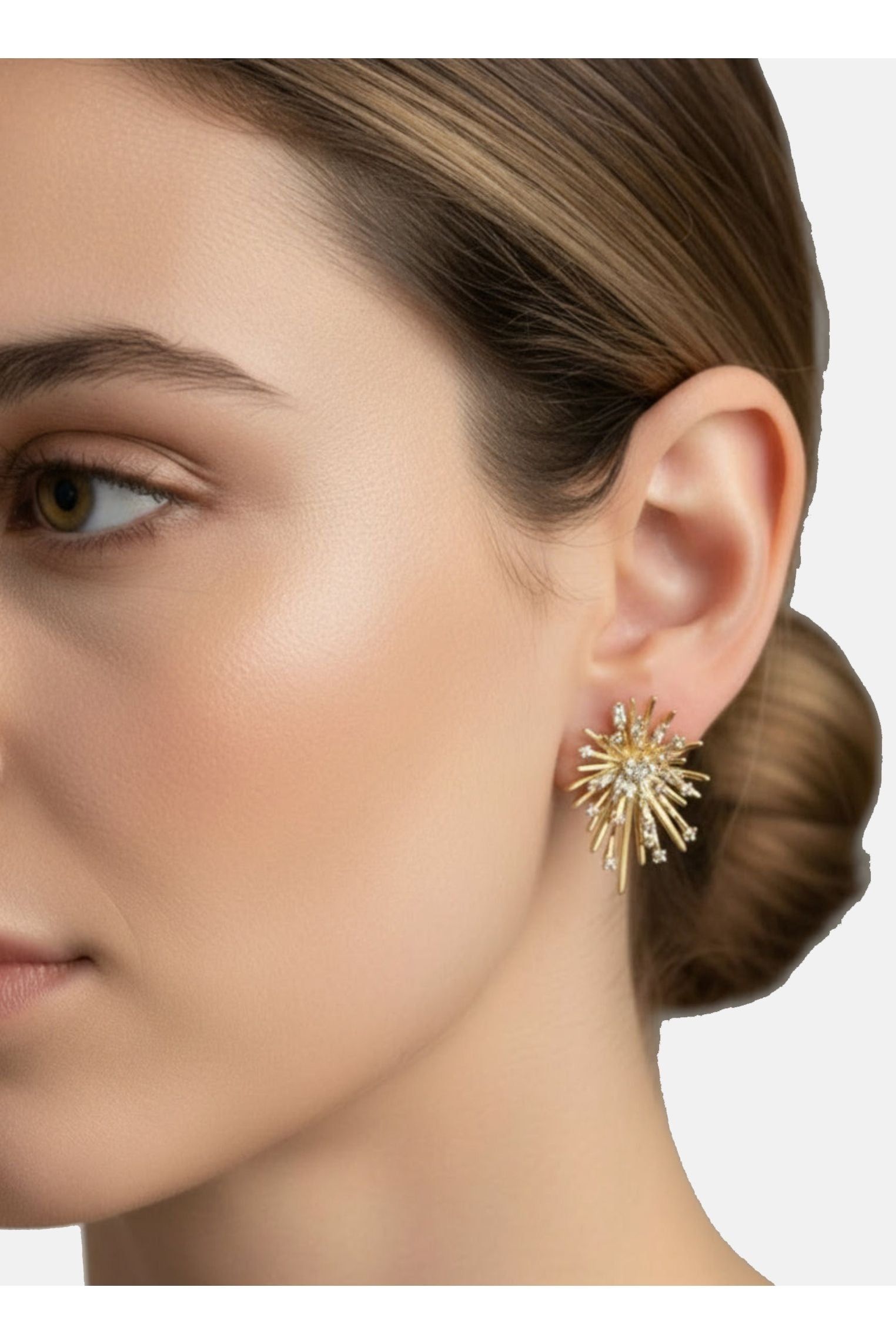 Close-up of a woman wearing a gold earring with a starburst design.