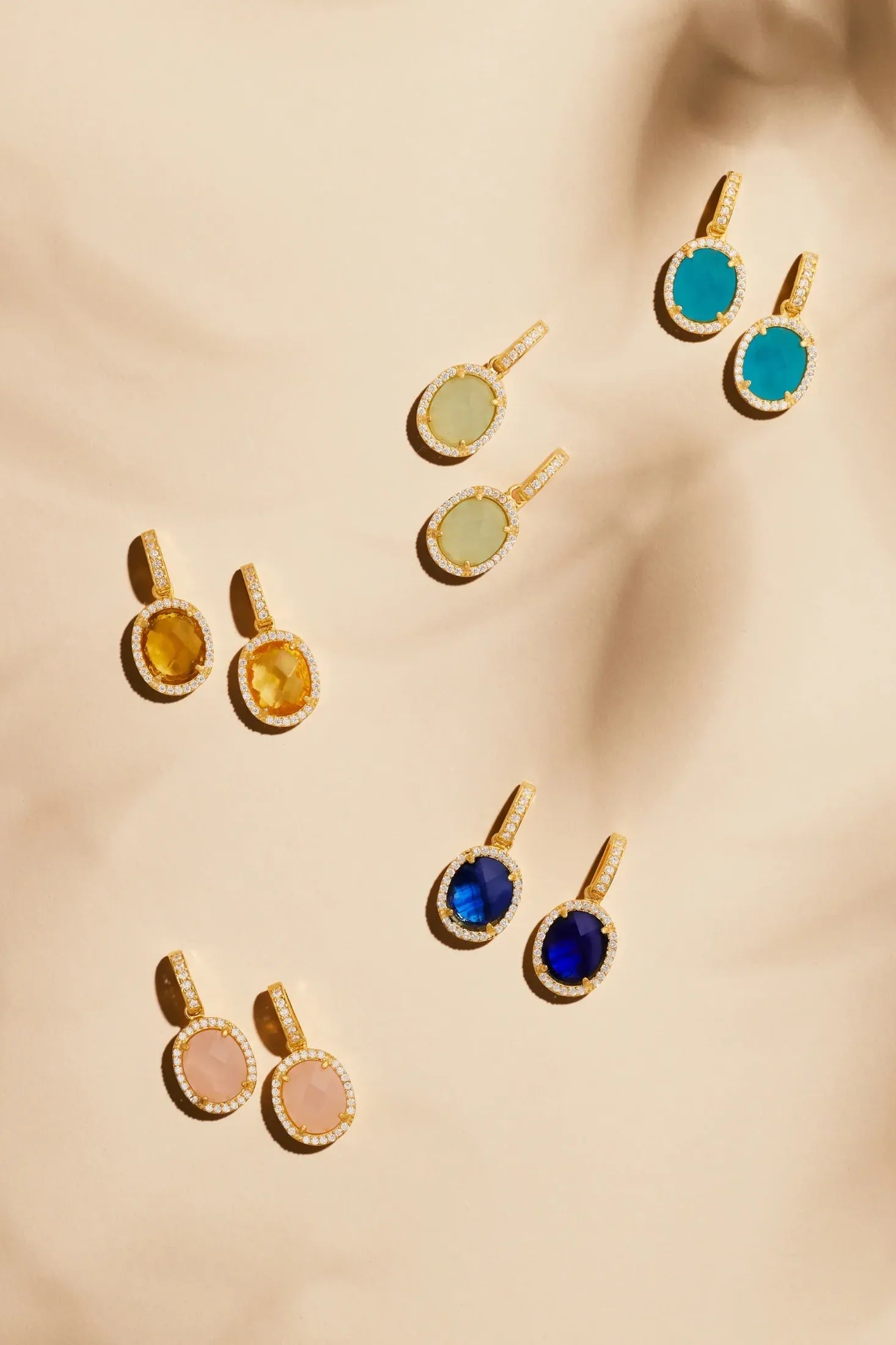 Beatrice Oval Gemstone Drop Earrings Gold Blue Topaz Hydro worn by a model, showing how they sit on the ear and their scale.