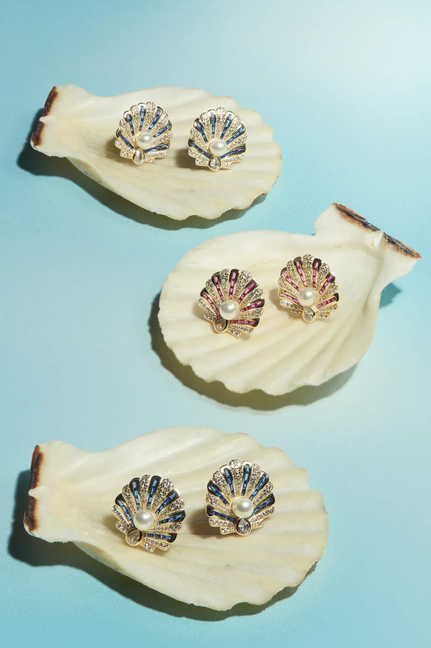 Art Deco Scallop Shell Earrings Sapphire Blue With Pearl Gold worn by a model, showing how they sit on the ear and their scale.