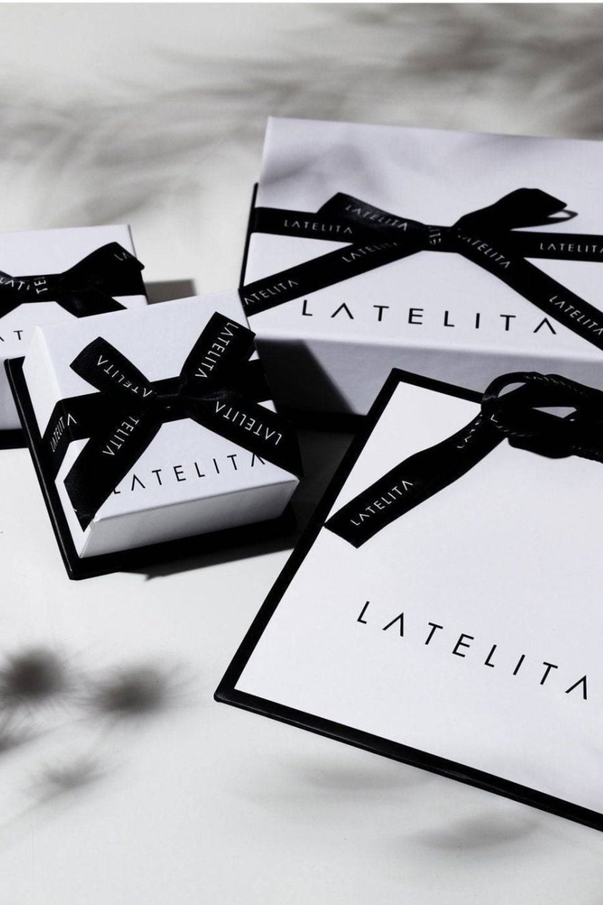 LATELITA boxes with black ribbons on a white background