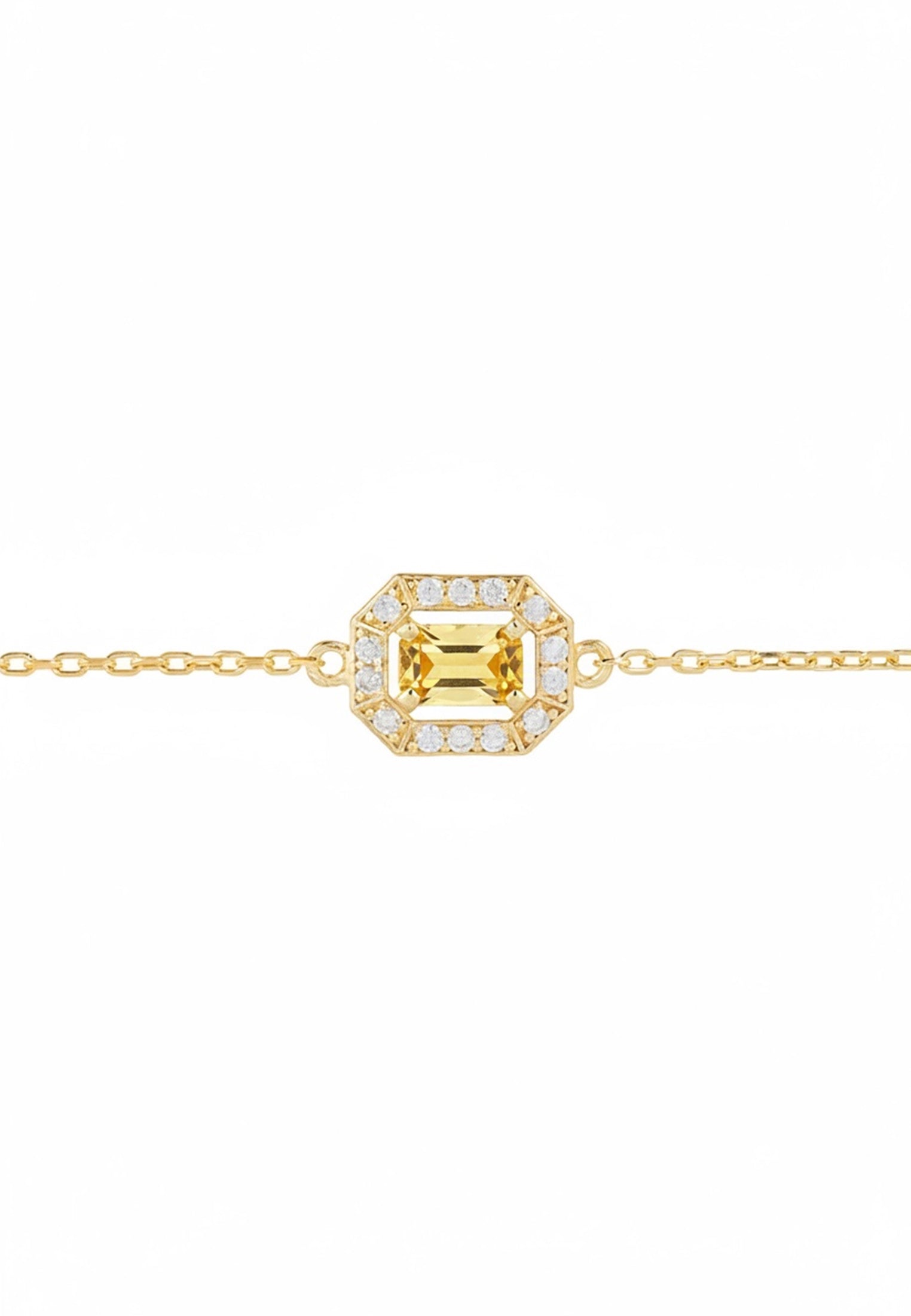 Gold bracelet with a green gemstone in the centre surrounded by diamonds