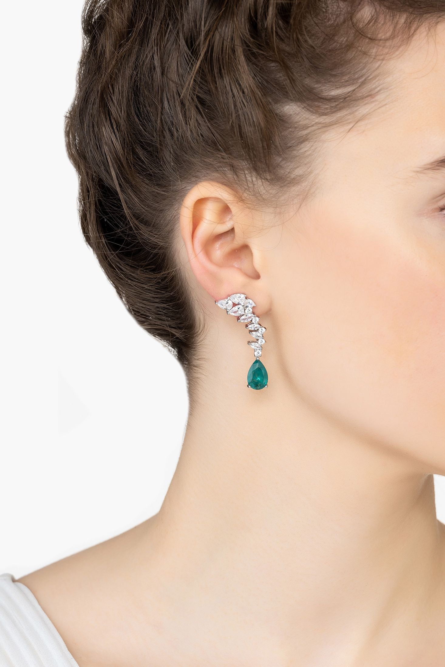 Angled view of Henriette Teardrop Earrings Emerald Silver, showing emerald detailing, silver finish and the jewellery profile.