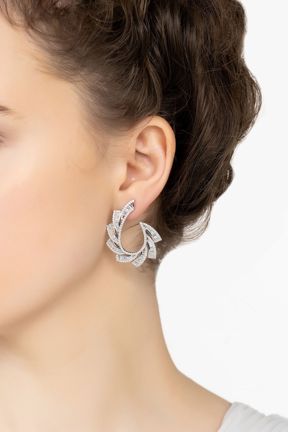 Angled view of Amara Sweeping Hoop Earrings Silver, showing silver finish and the jewellery profile.