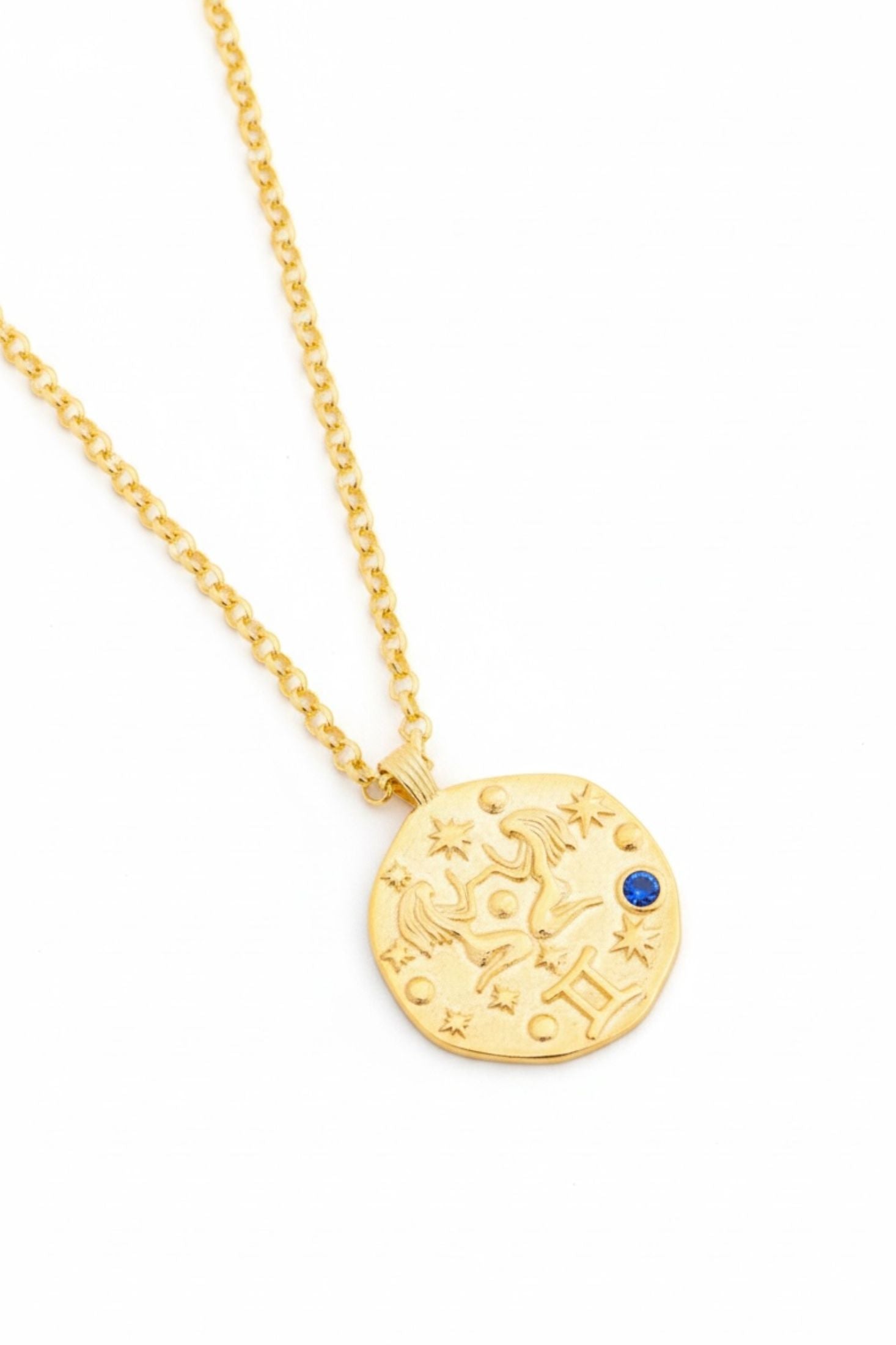 Gold necklace with a round pendant on a white background