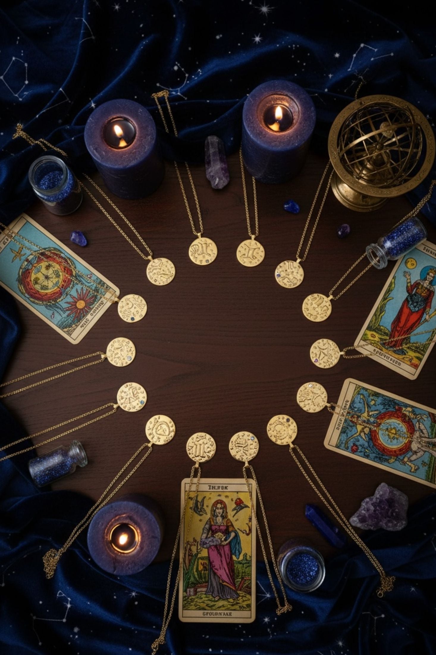 Tarot cards, candles, and gold pendant necklaces arranged in a circle on a dark background
