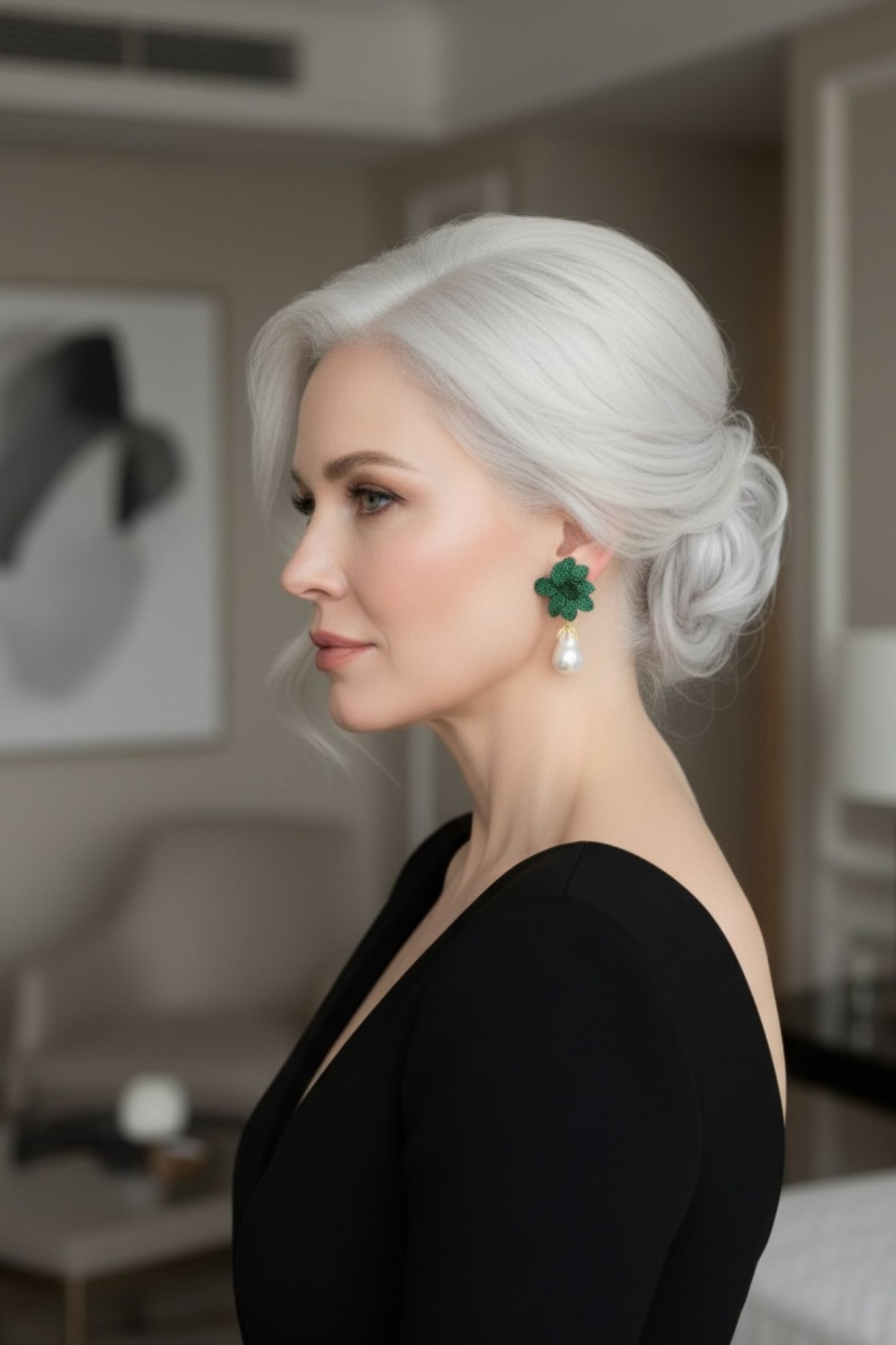 Woman with styled hair wearing green earrings with pearl drops