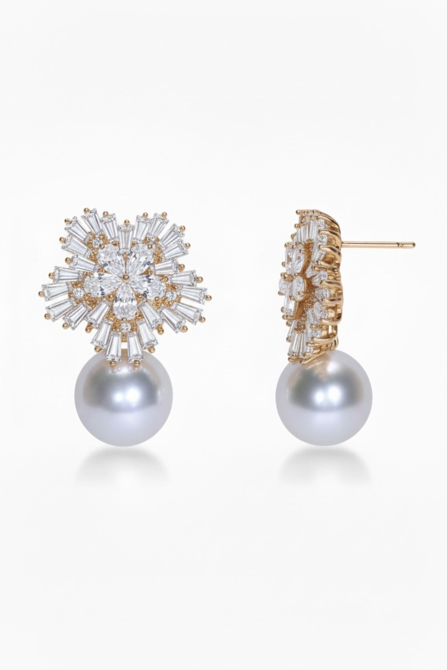 Pair of pearl earrings with gold and crystal embellishments on a white background